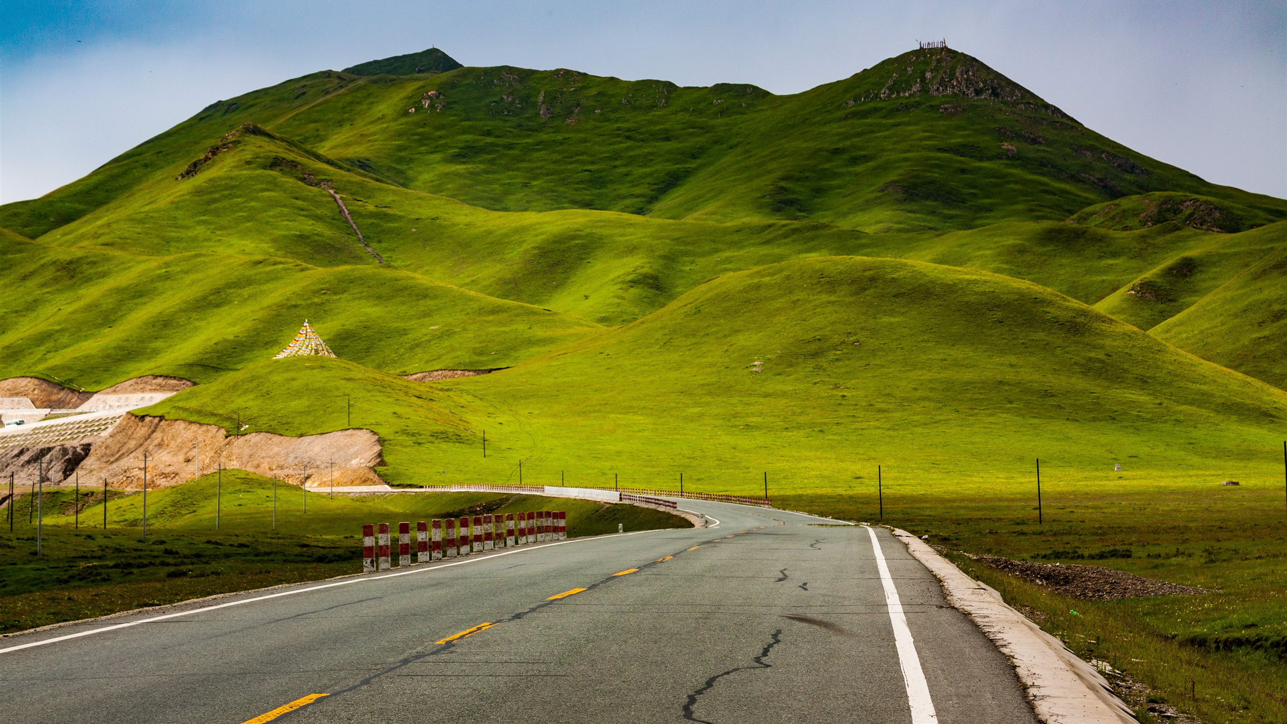 Free photo A picture of a paved road by the green hills