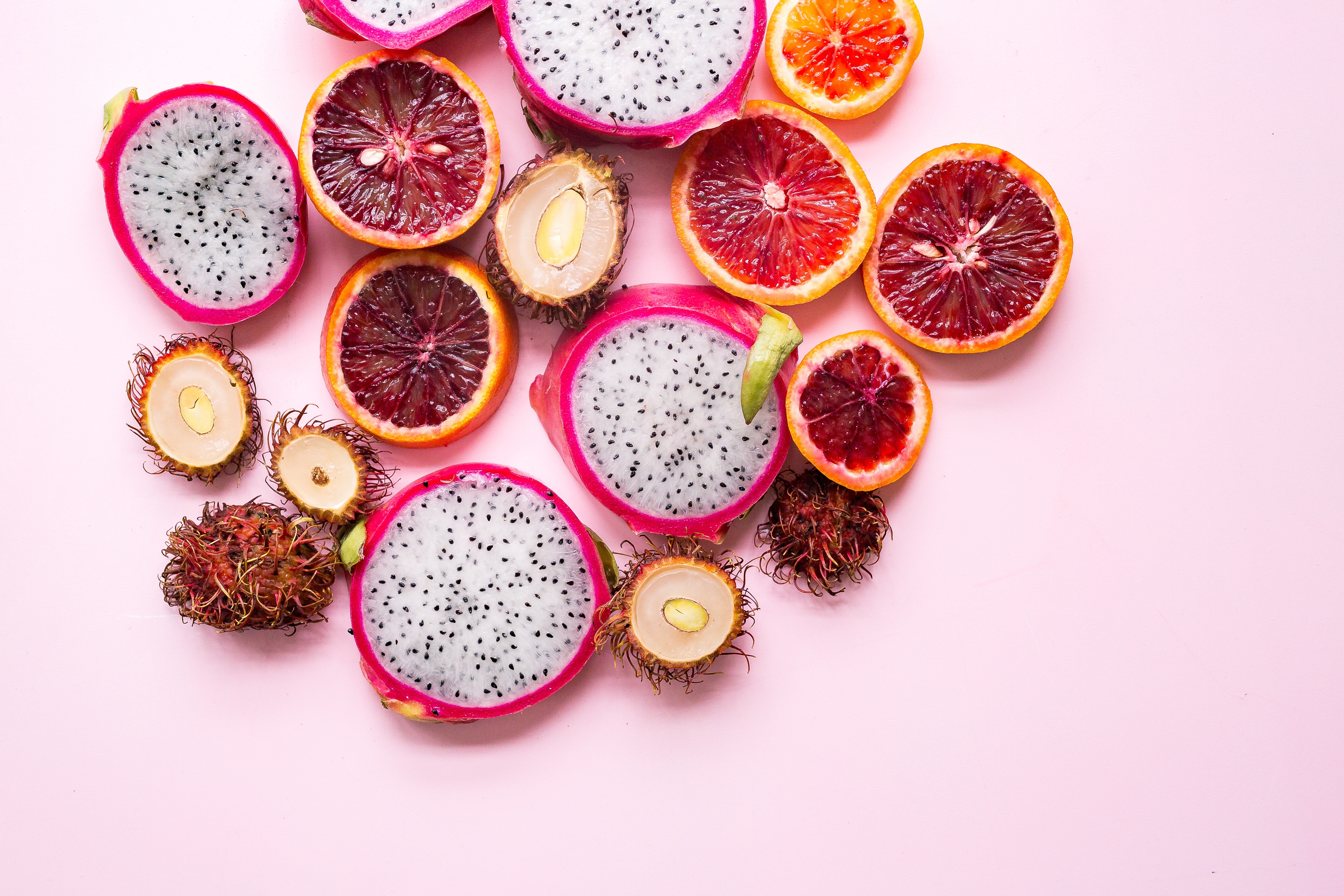 Free photo Exotic rambutan fruit with pitaya on a pink background