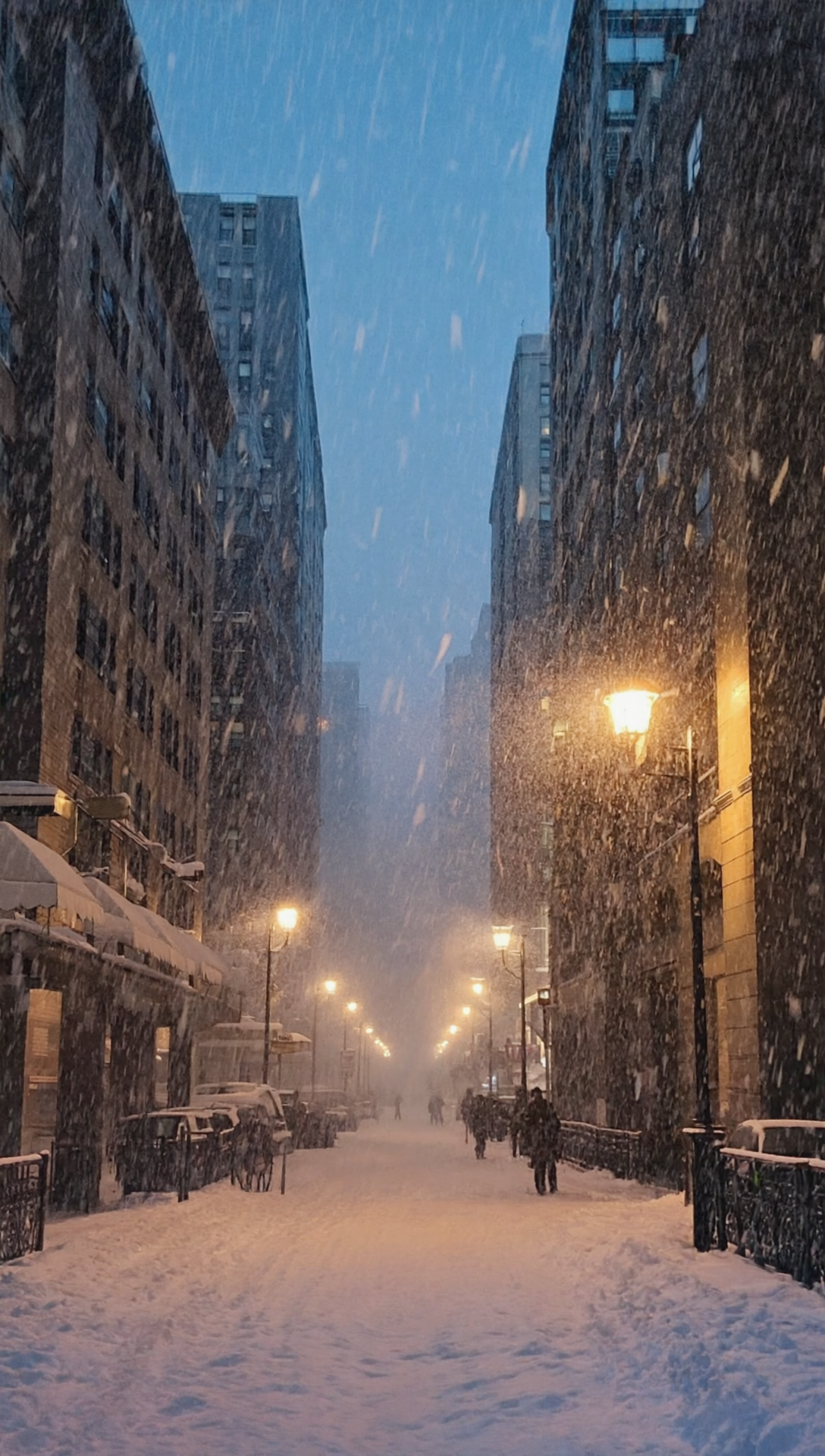 Бесплатное фото Обои на телефон, пейзаж зимой идёт снег на улицах города и горят фонари