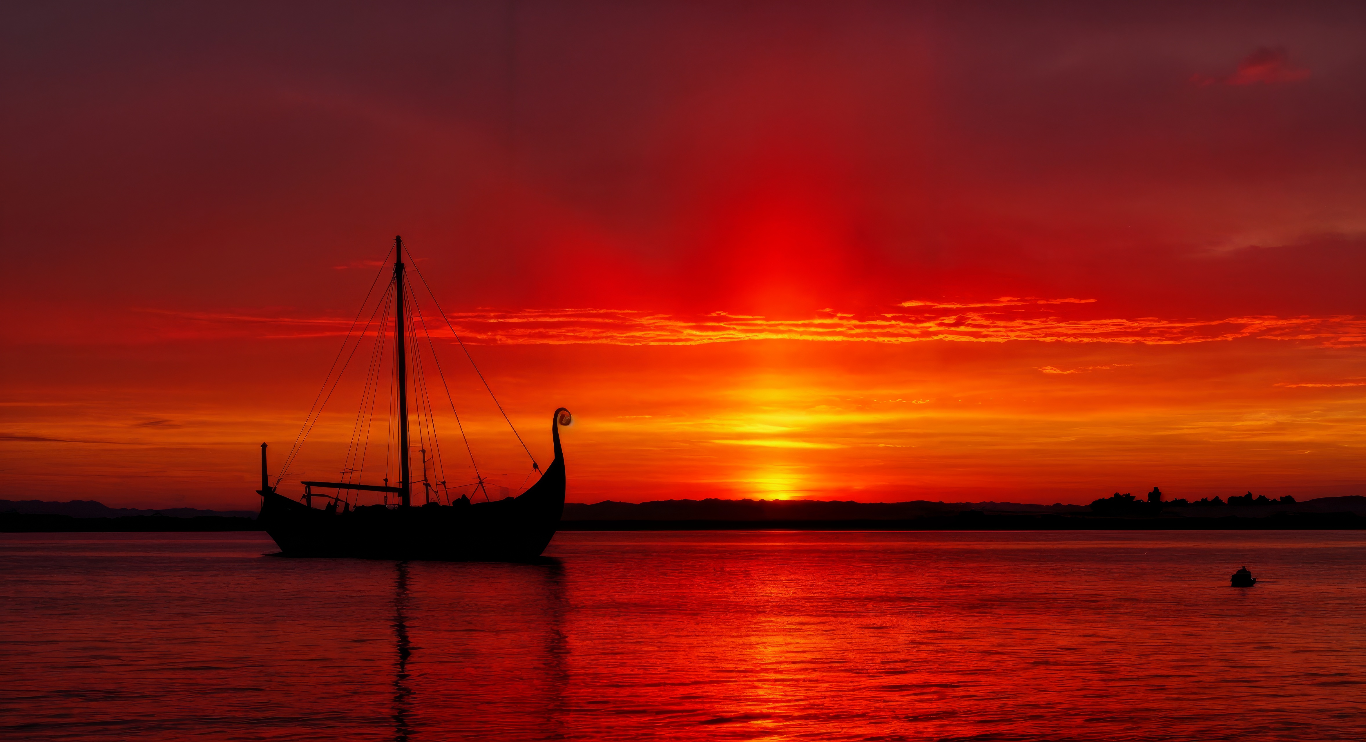 Бесплатное фото Лодка на воде во время красно-оранжевого заката