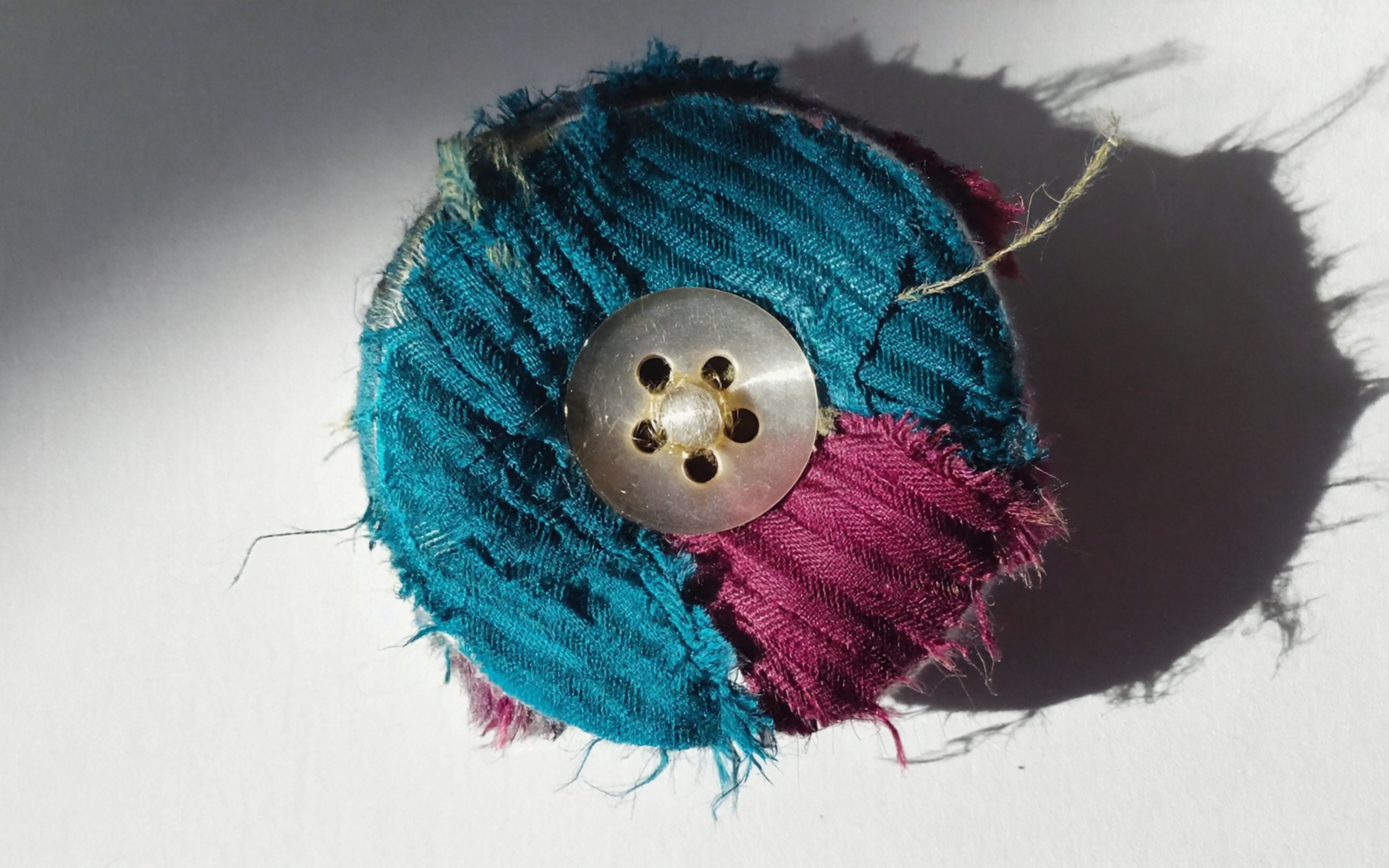 Free photo Abstract photo: a button strangely sewn with threads