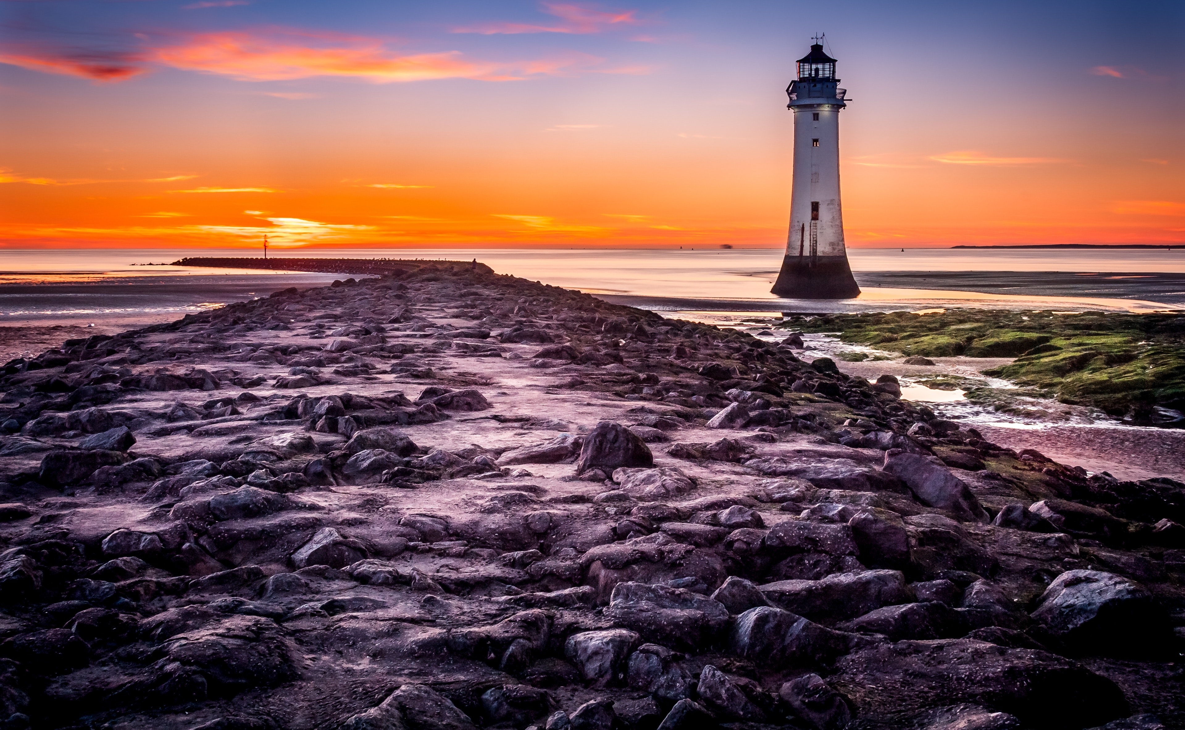 Lighthouse on the seashore during sunset