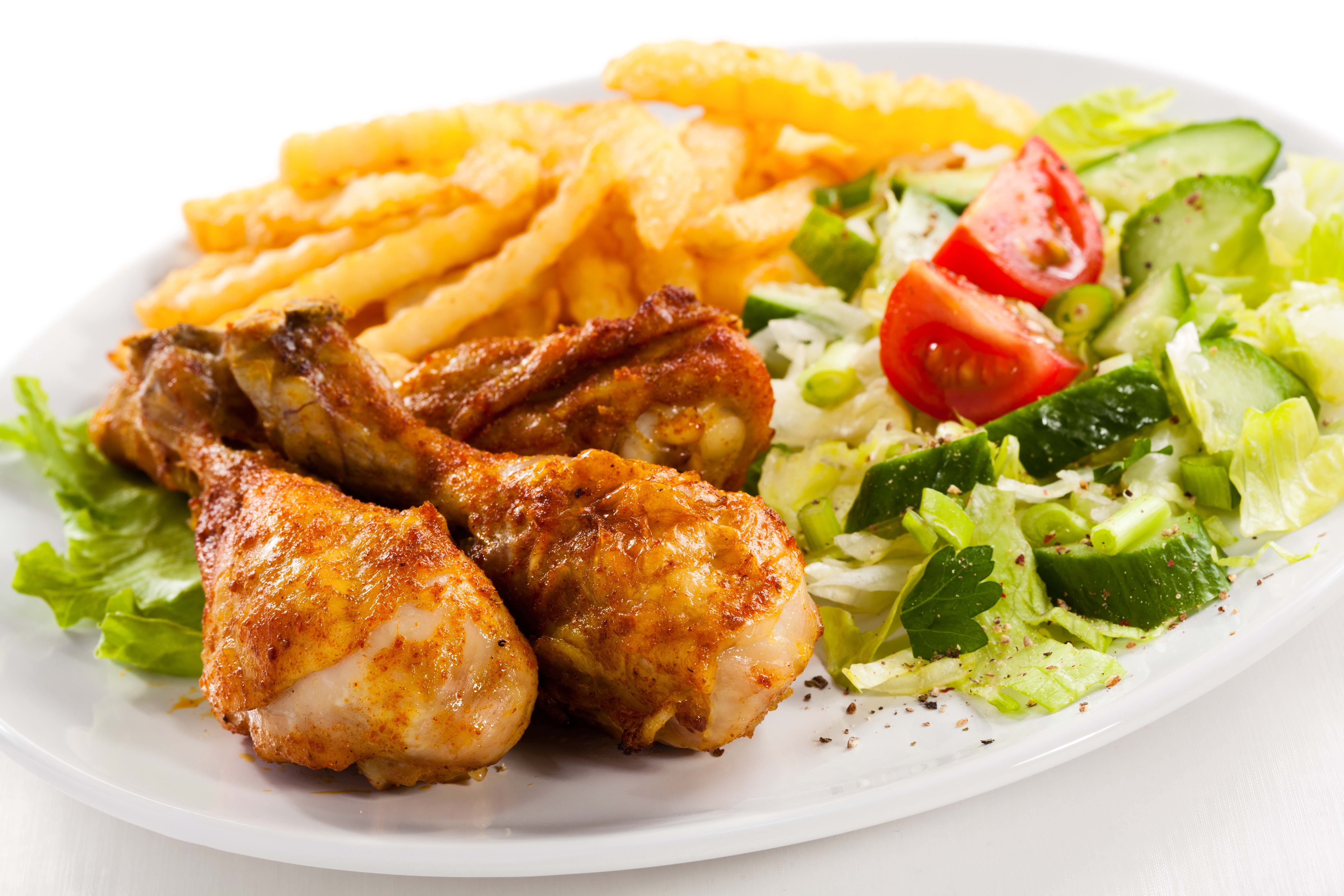 Chicken drumsticks with French fries and salad