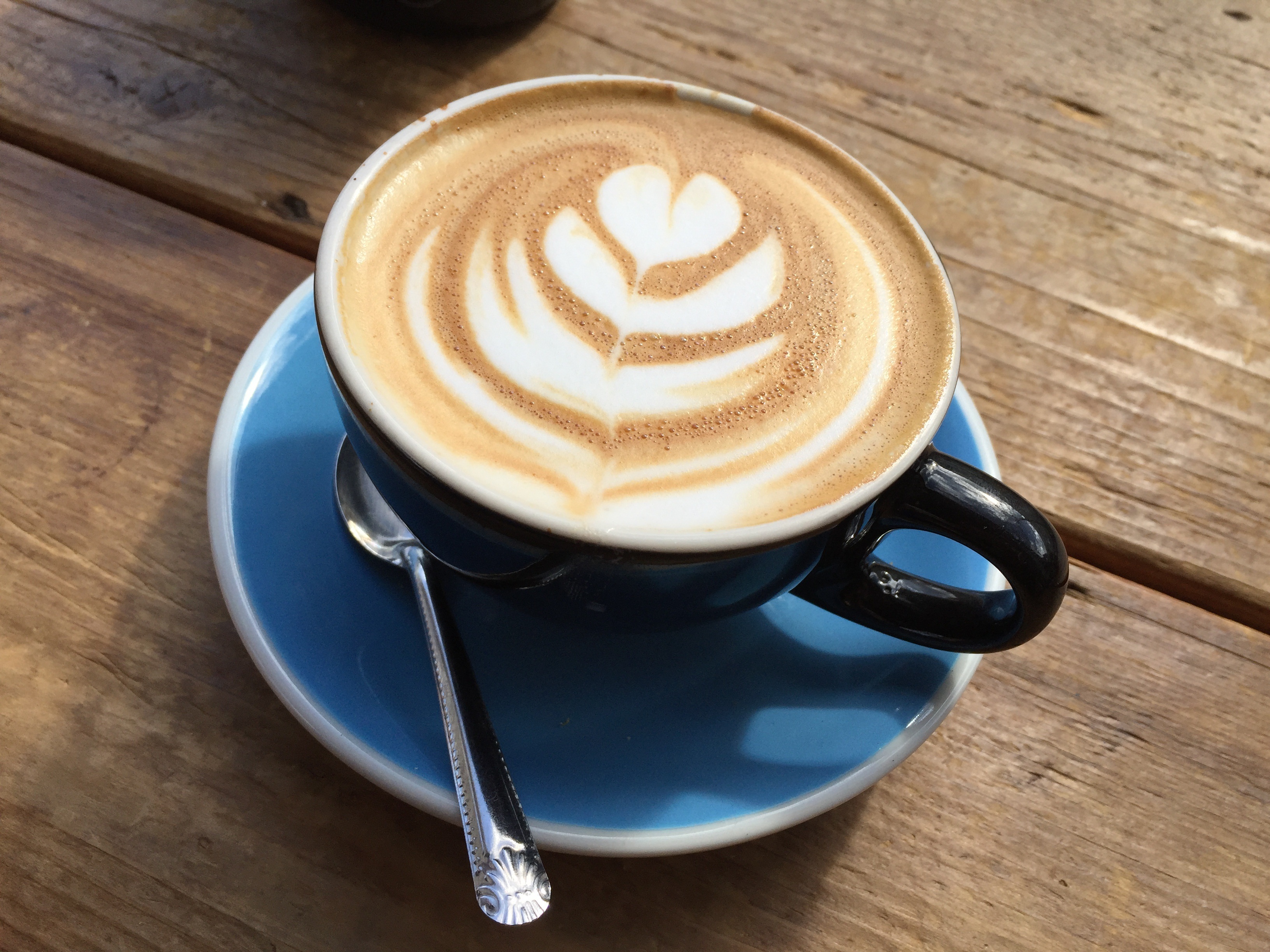 Free photo Coffee cup with a pattern of a flower on the foam