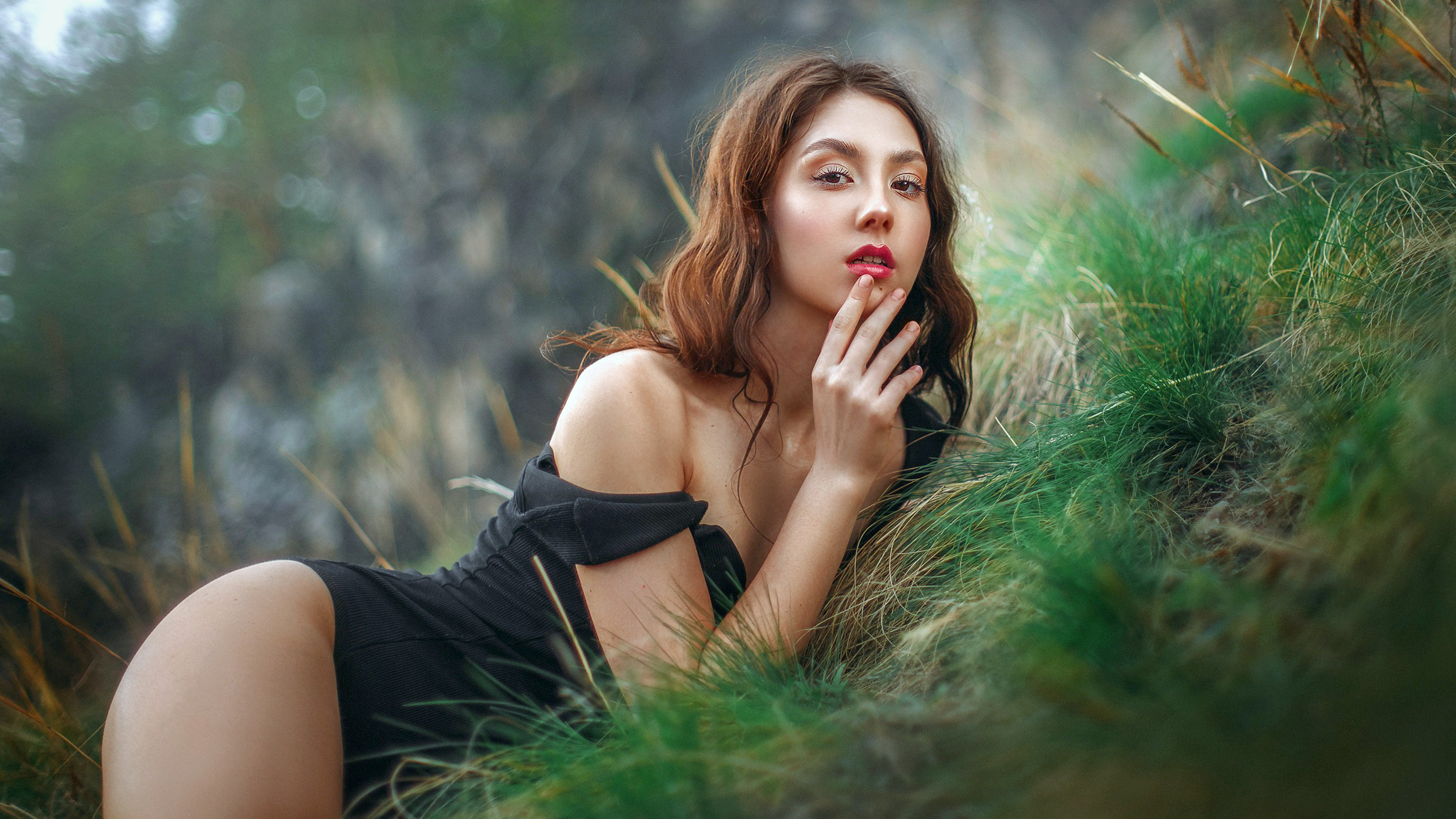 Beautiful girl with red lips posing in the grass