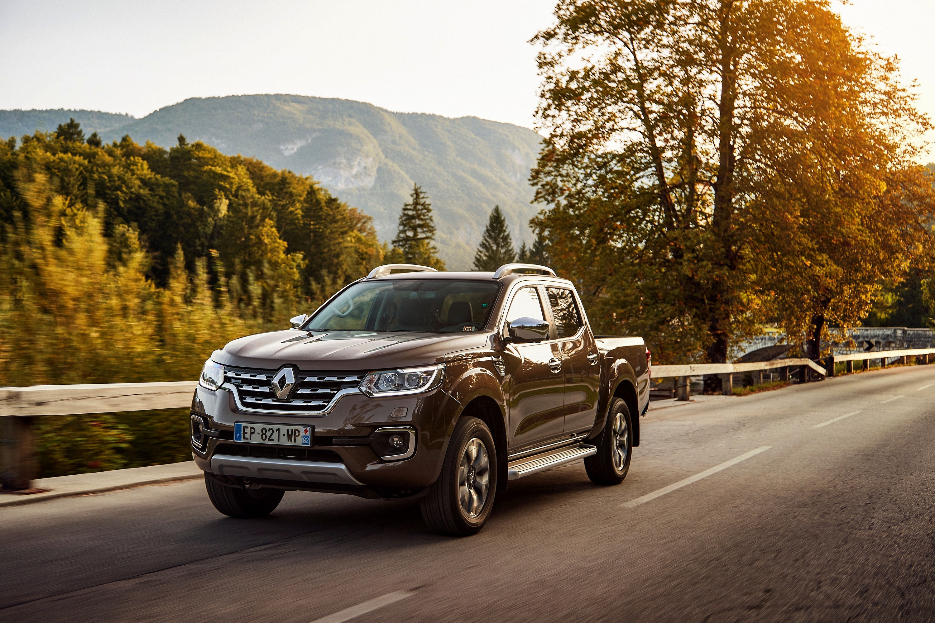 Бесплатное фото Коричневый пикап renault alaskan едет по дороге