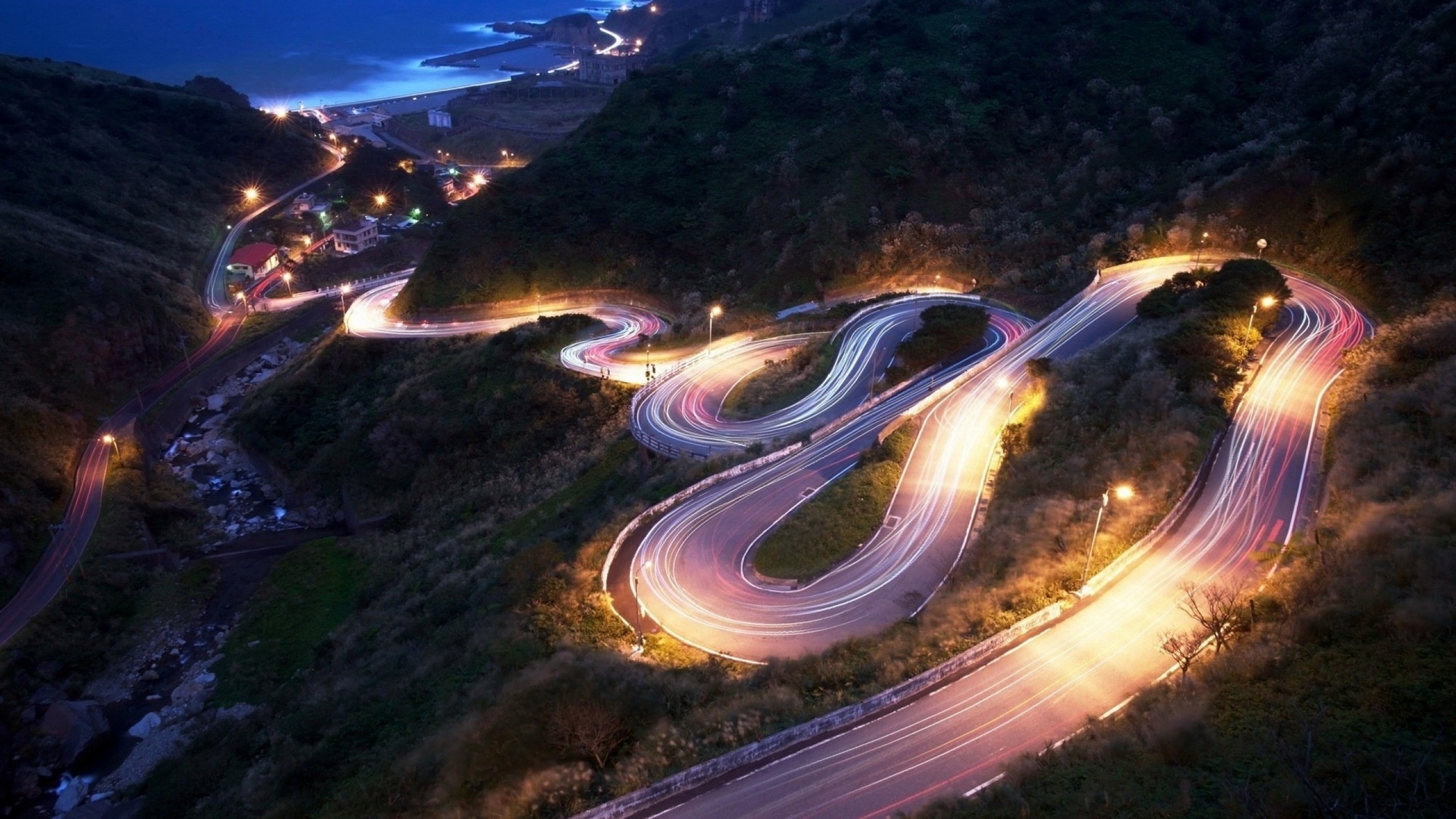 Free photo A nighttime winding road going down the side of a mountain.