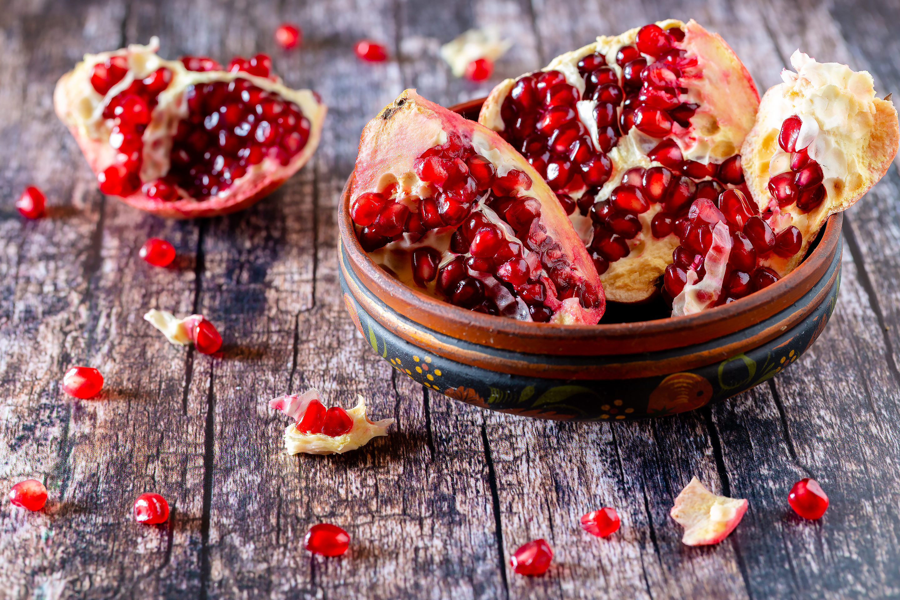 Разломанный гранат в деревянной тарелке