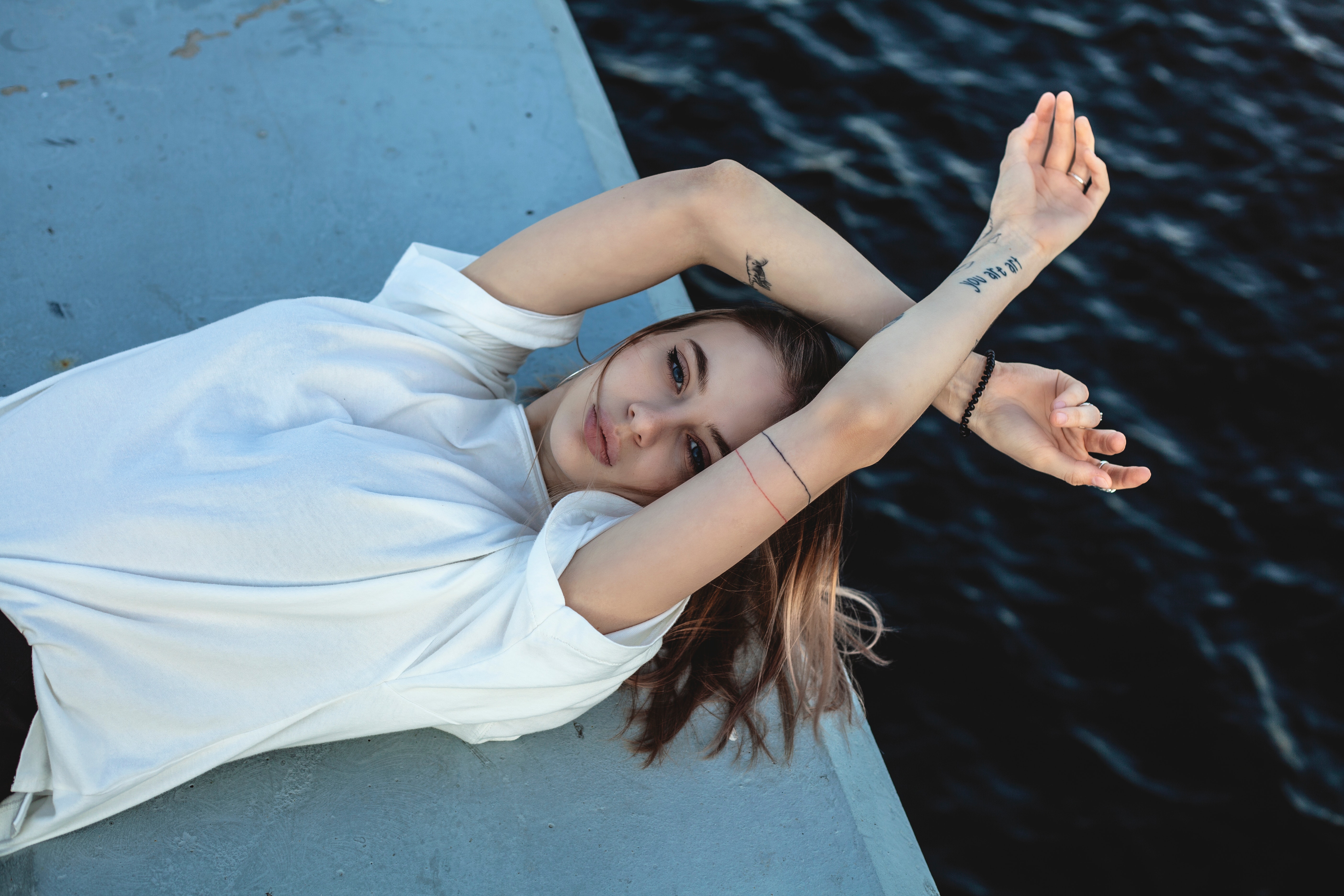 Free photo Brown-haired girl with tattoos poses on a boat