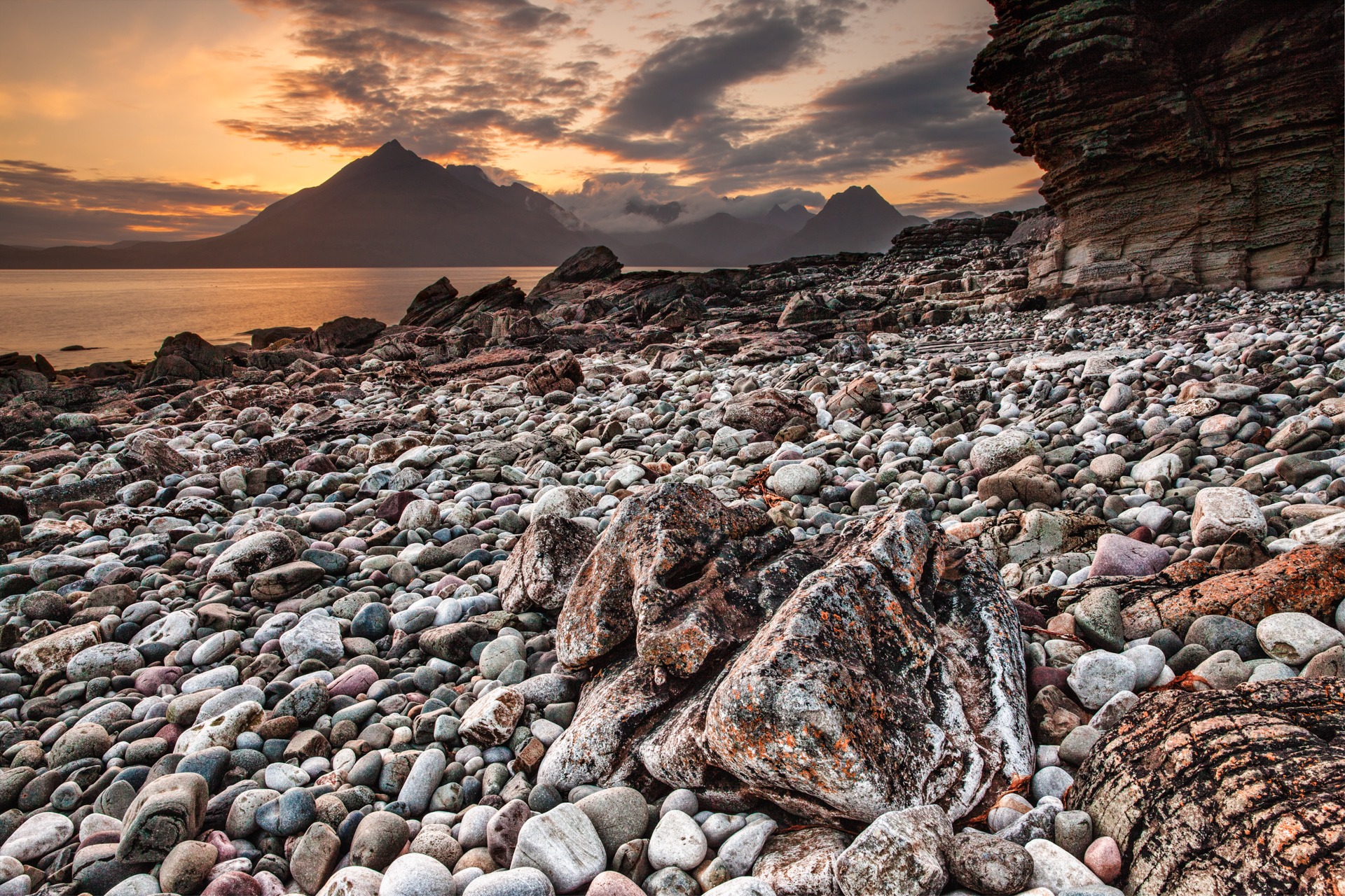 A rocky seashore with a mountain in the distance