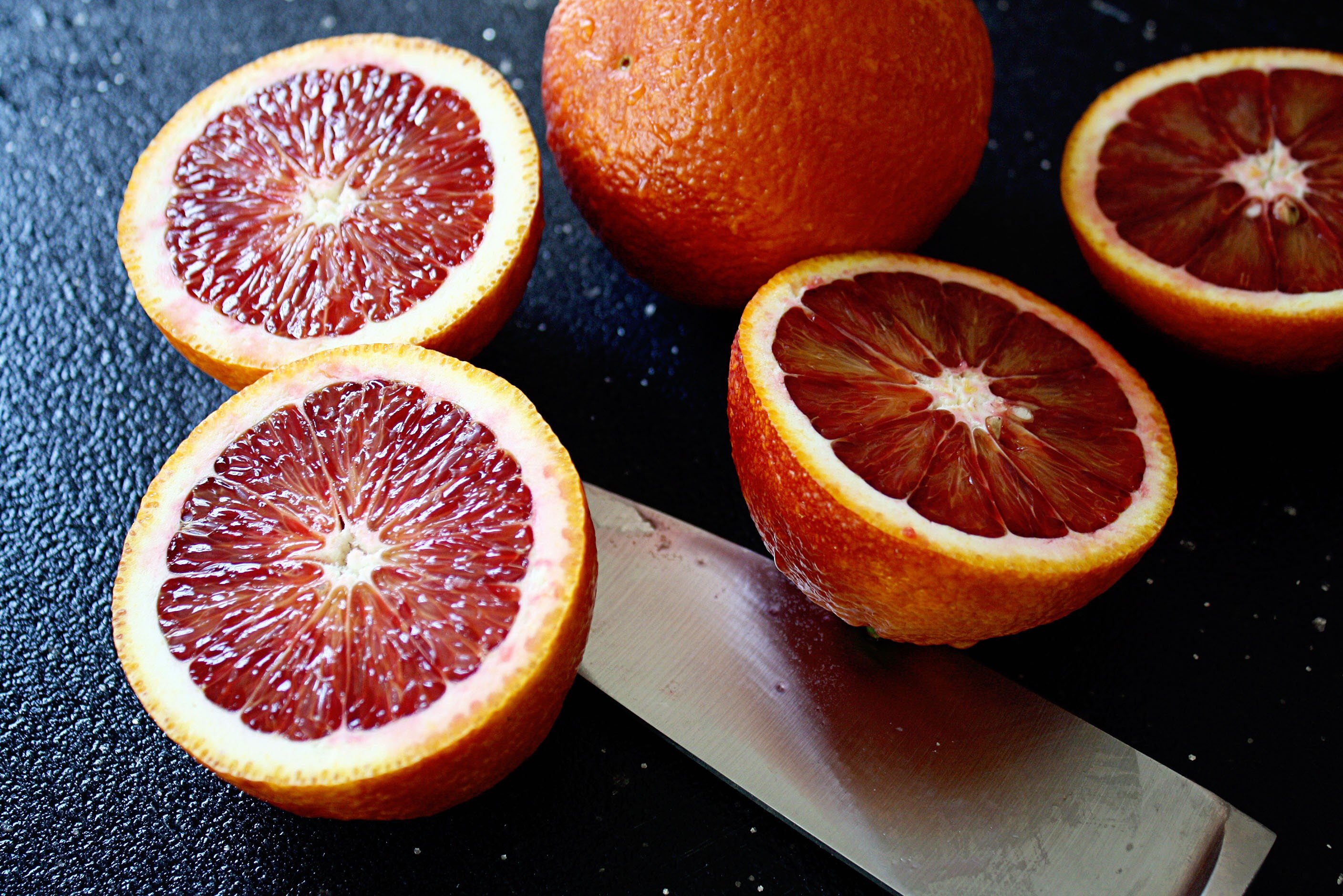 Free photo Cut citrus fruit on the table with a knife