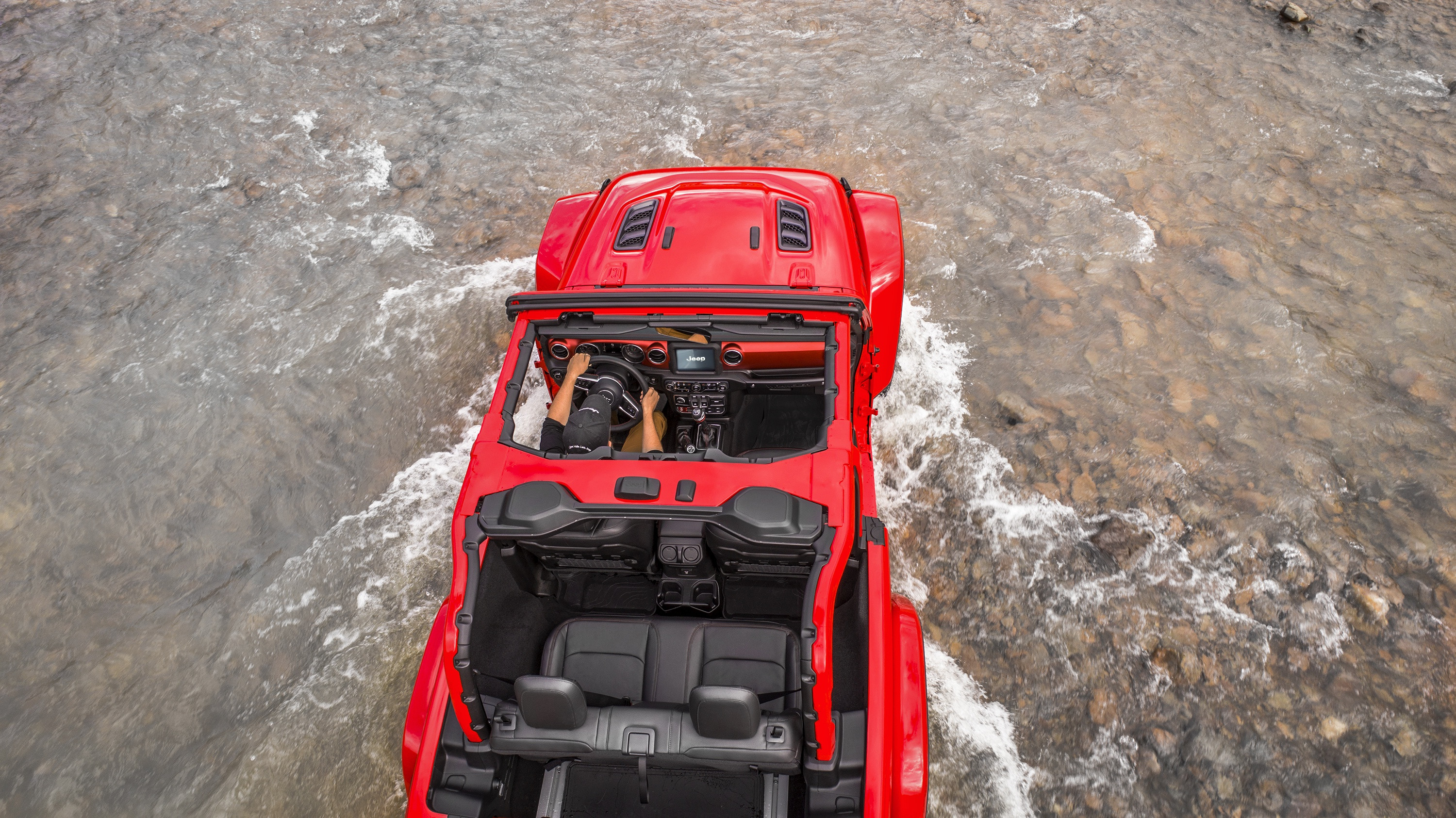 红色吉普车Wrangler Rubicon穿越浅水河