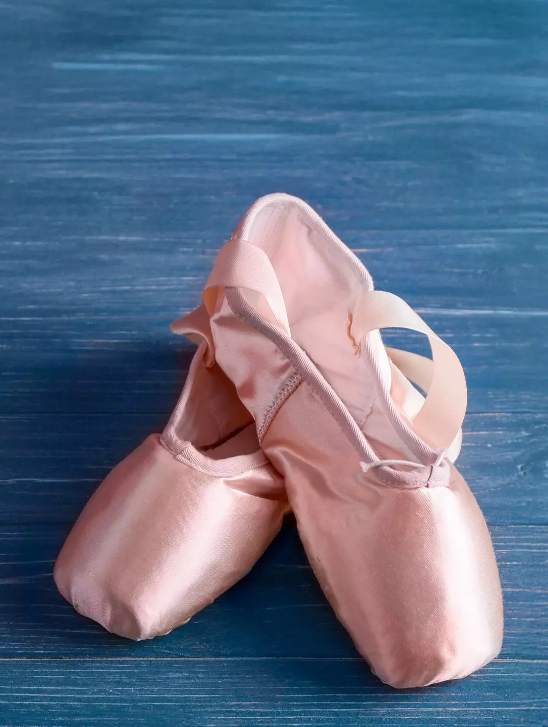 Бесплатное фото Розовые пуанты на синем фоне