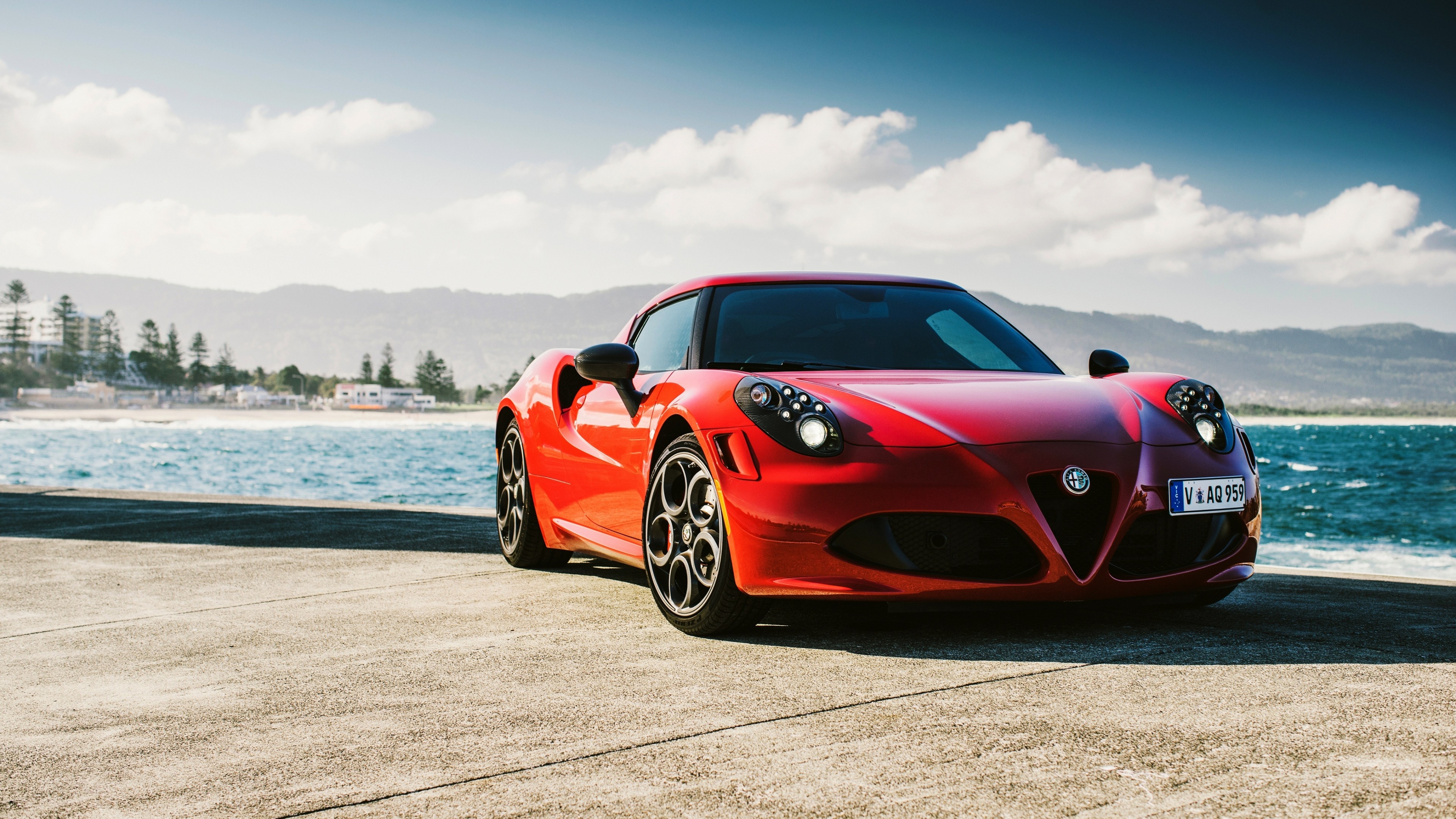 Free photo A red Alfa Romeo 4C against the sea.