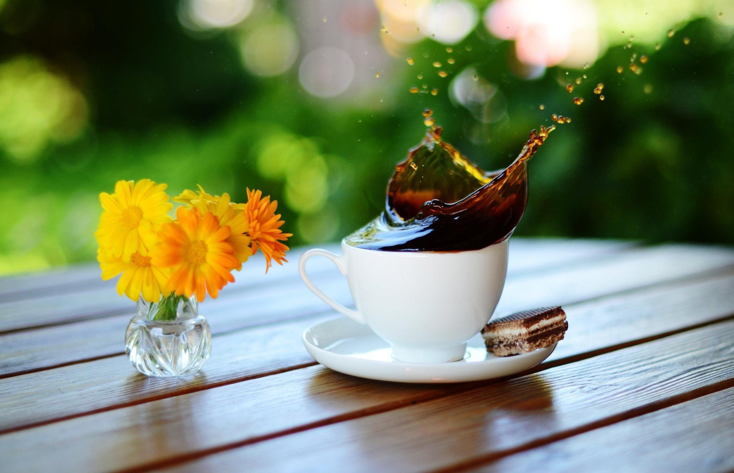 桌上的白杯中溅起一朵咖啡花