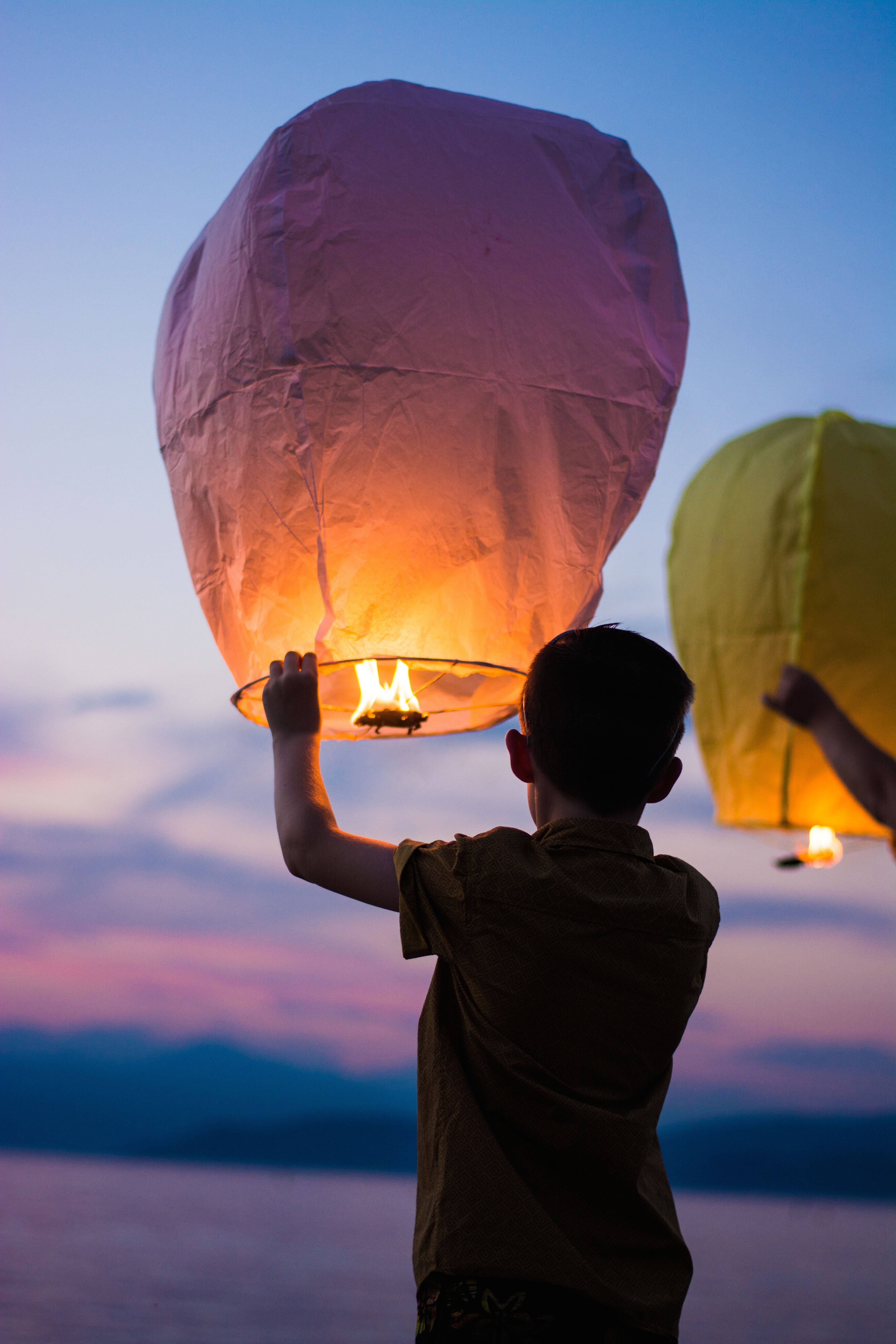 Free photo People launch Chinese lanterns