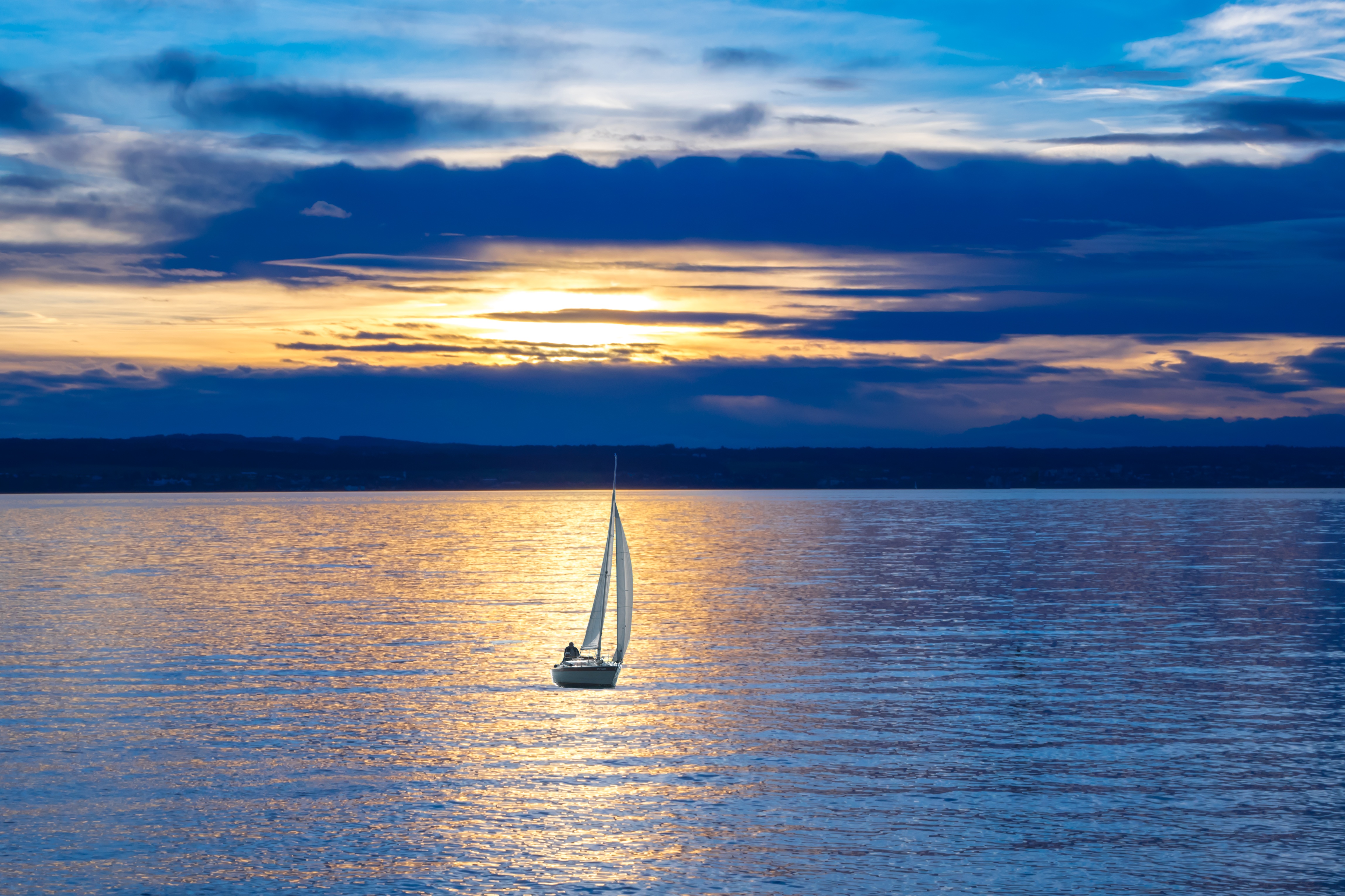 Free photo A lonely sailboat at sunset