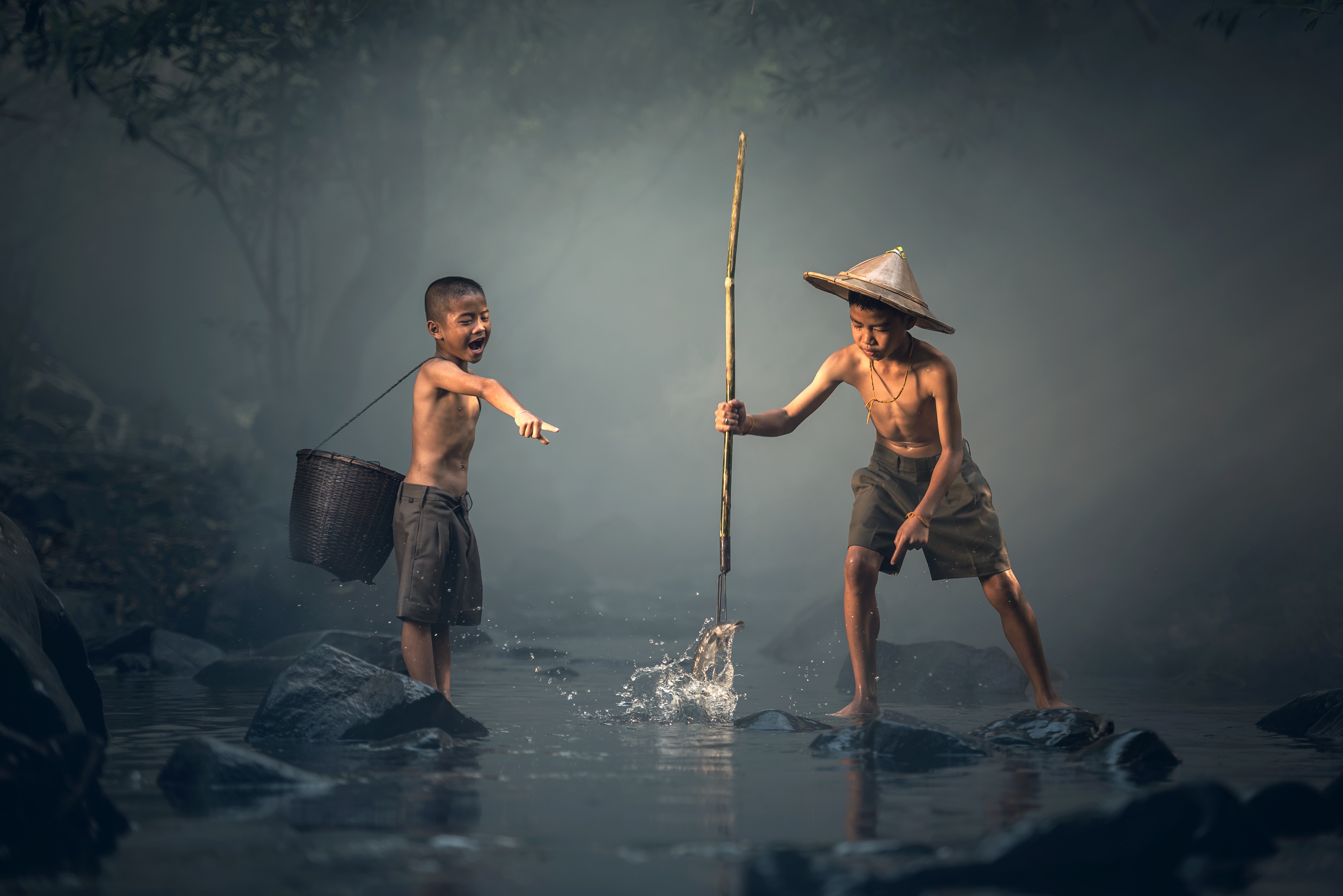两个亚洲男孩用鱼叉钓鱼。