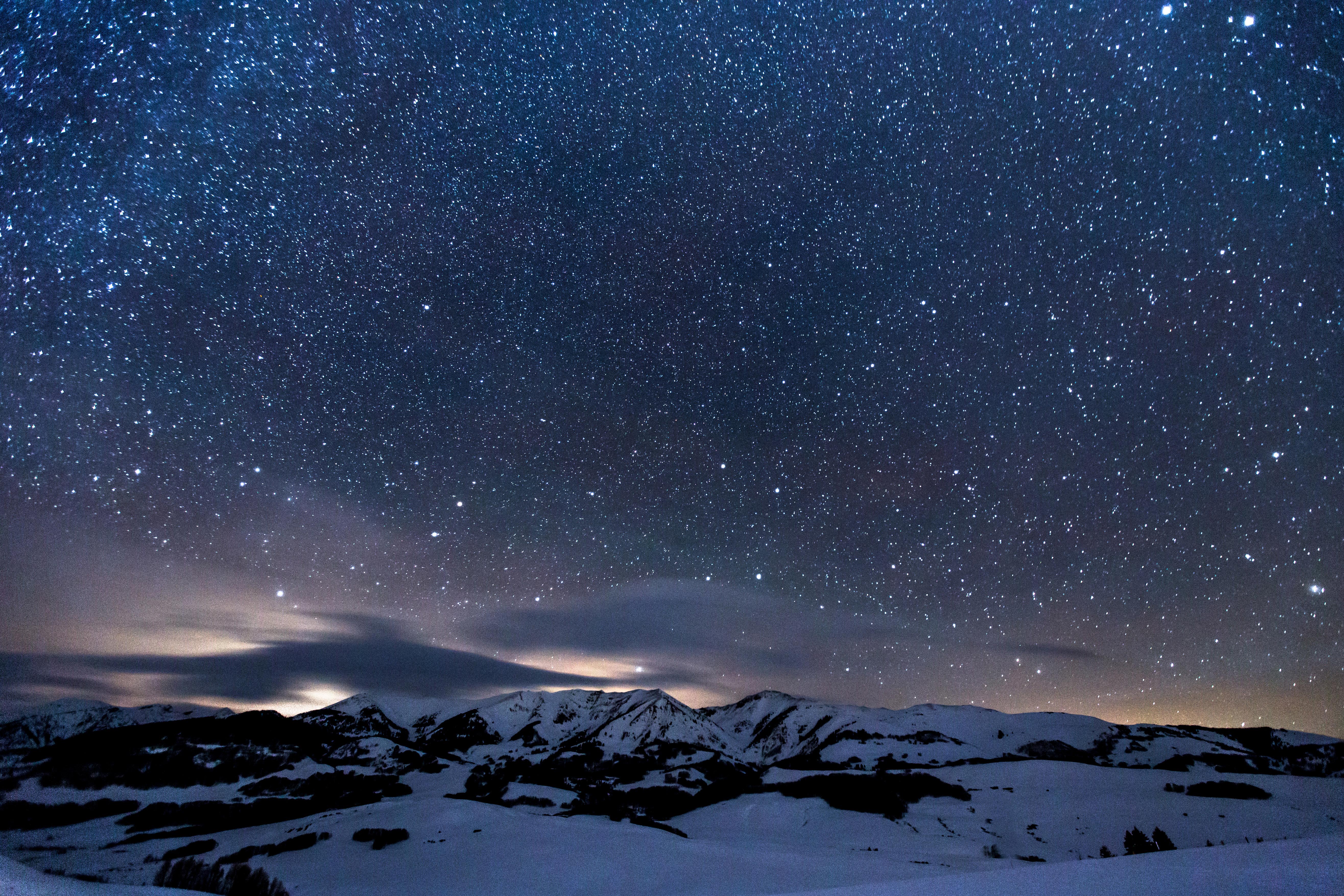 Evening starry sky over mountains covered with snow