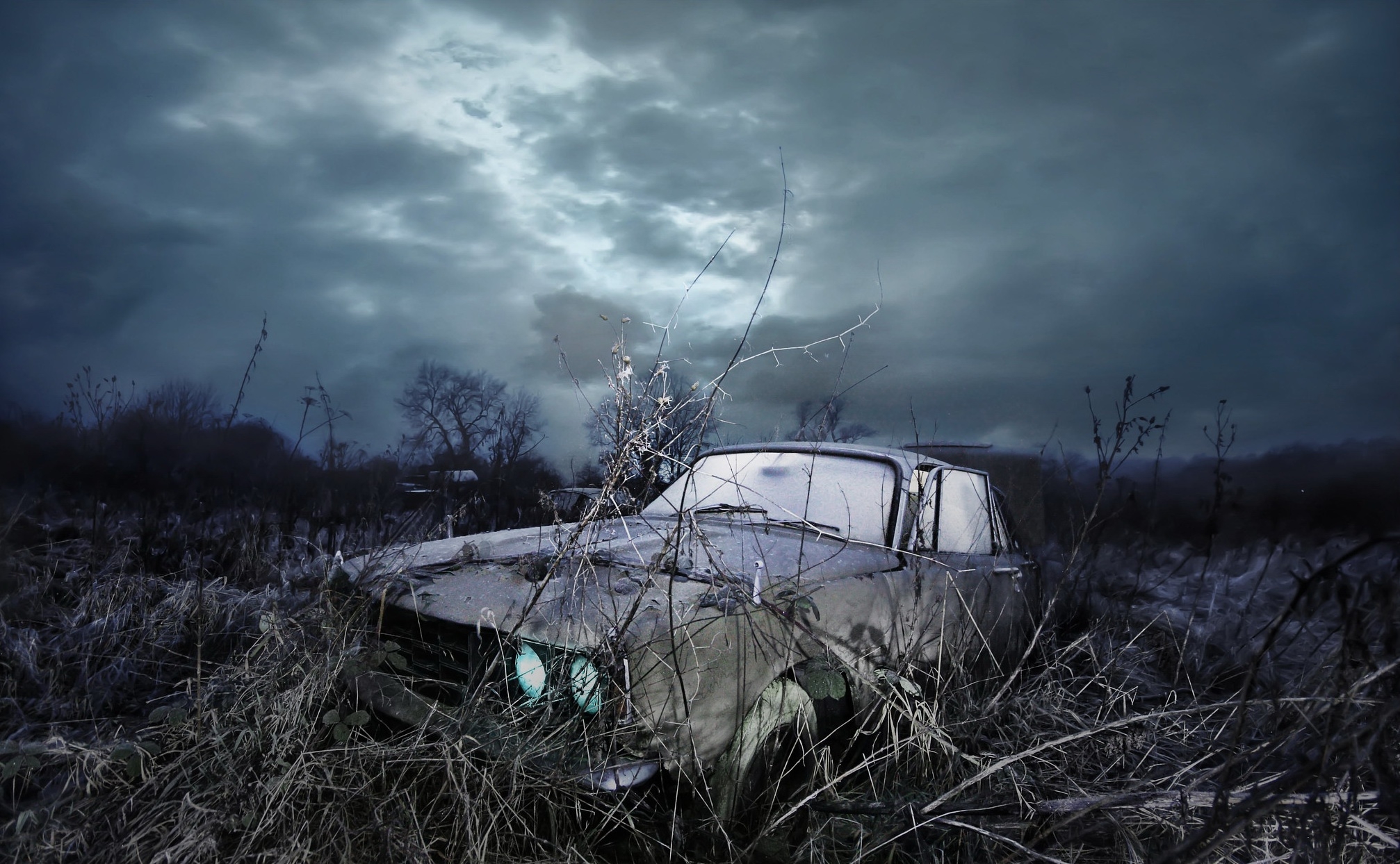 一辆被遗弃的汽车在恶劣天气中矗立在田野里