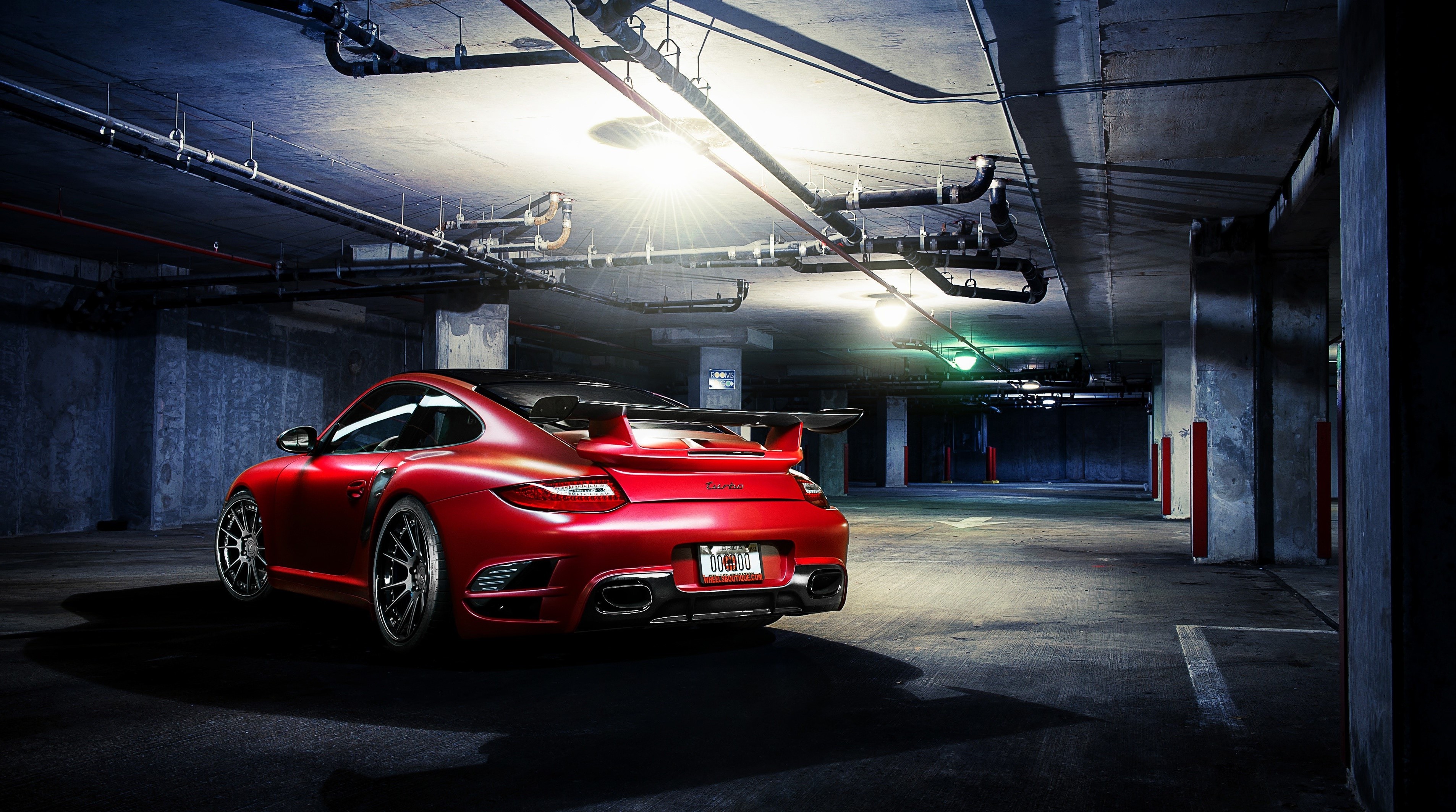 A red Porsche 911 in an underground parking garage is rear-ended.