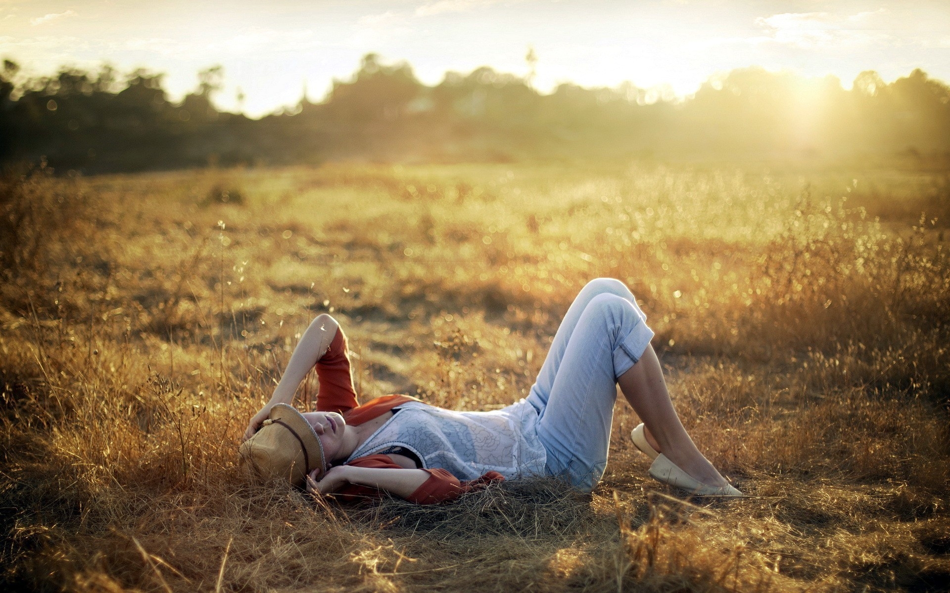 Free photo The girl in the hat is lying in the clearing enjoying the sunlight