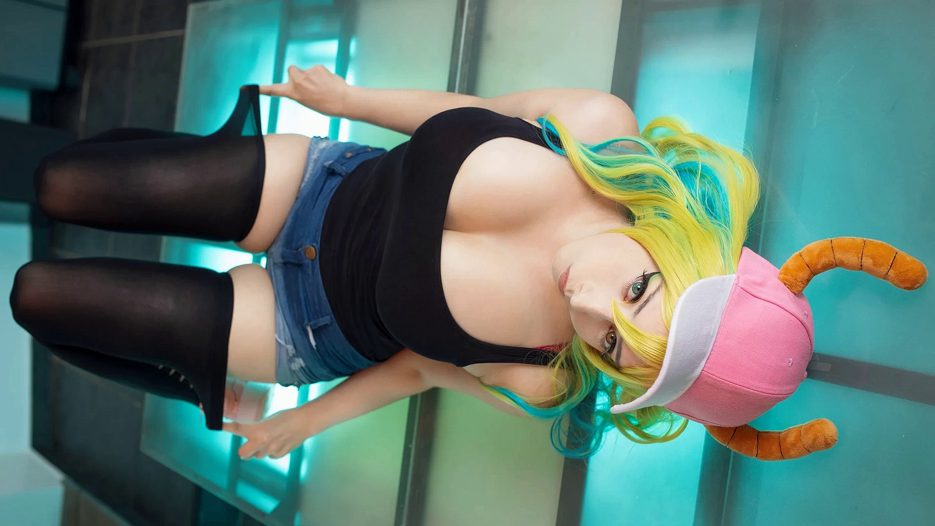 Модель Mikomi Hokina лежит на полу в розовой кепке