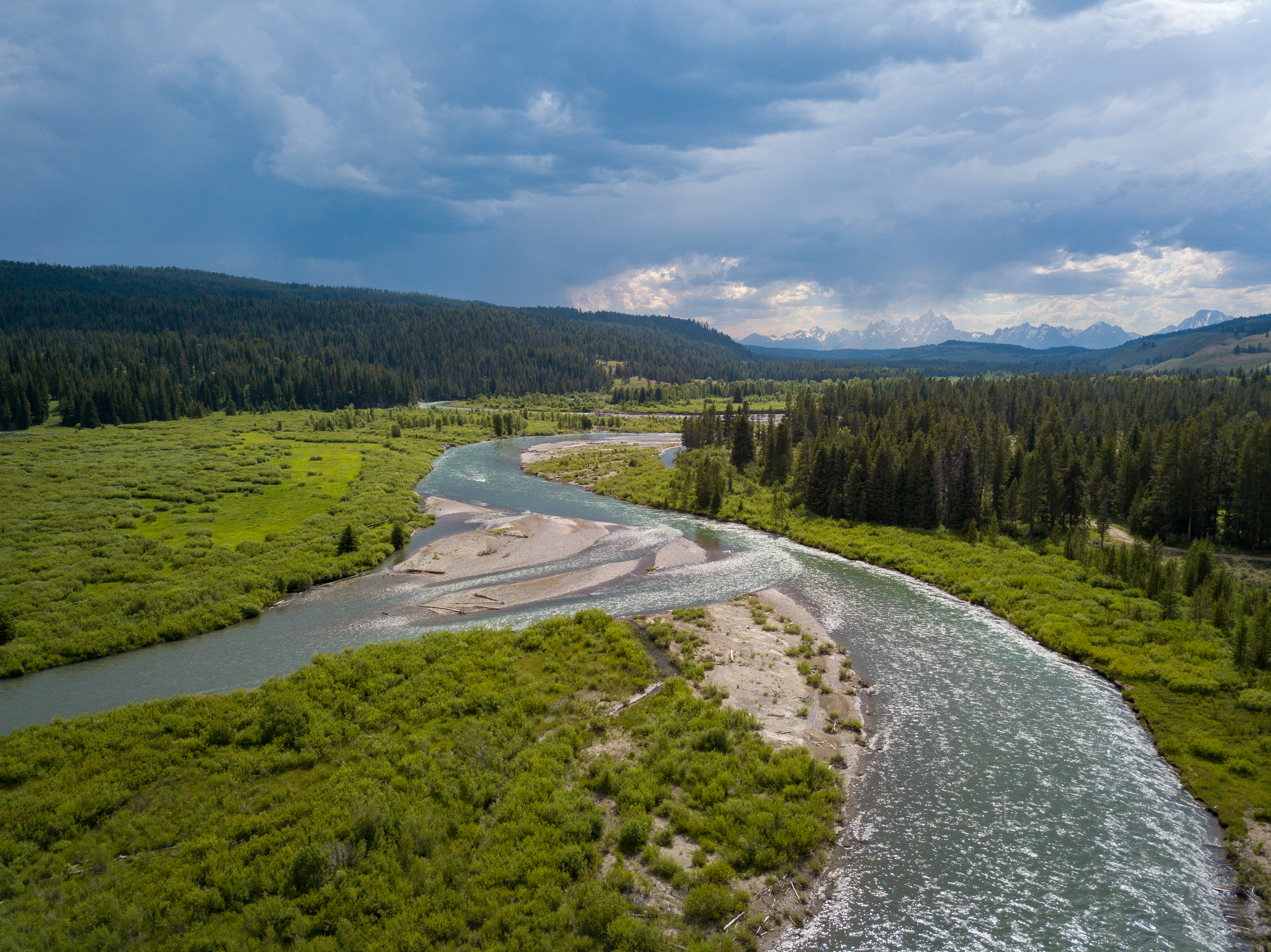 Free photo A shallow river in a field near the mountains