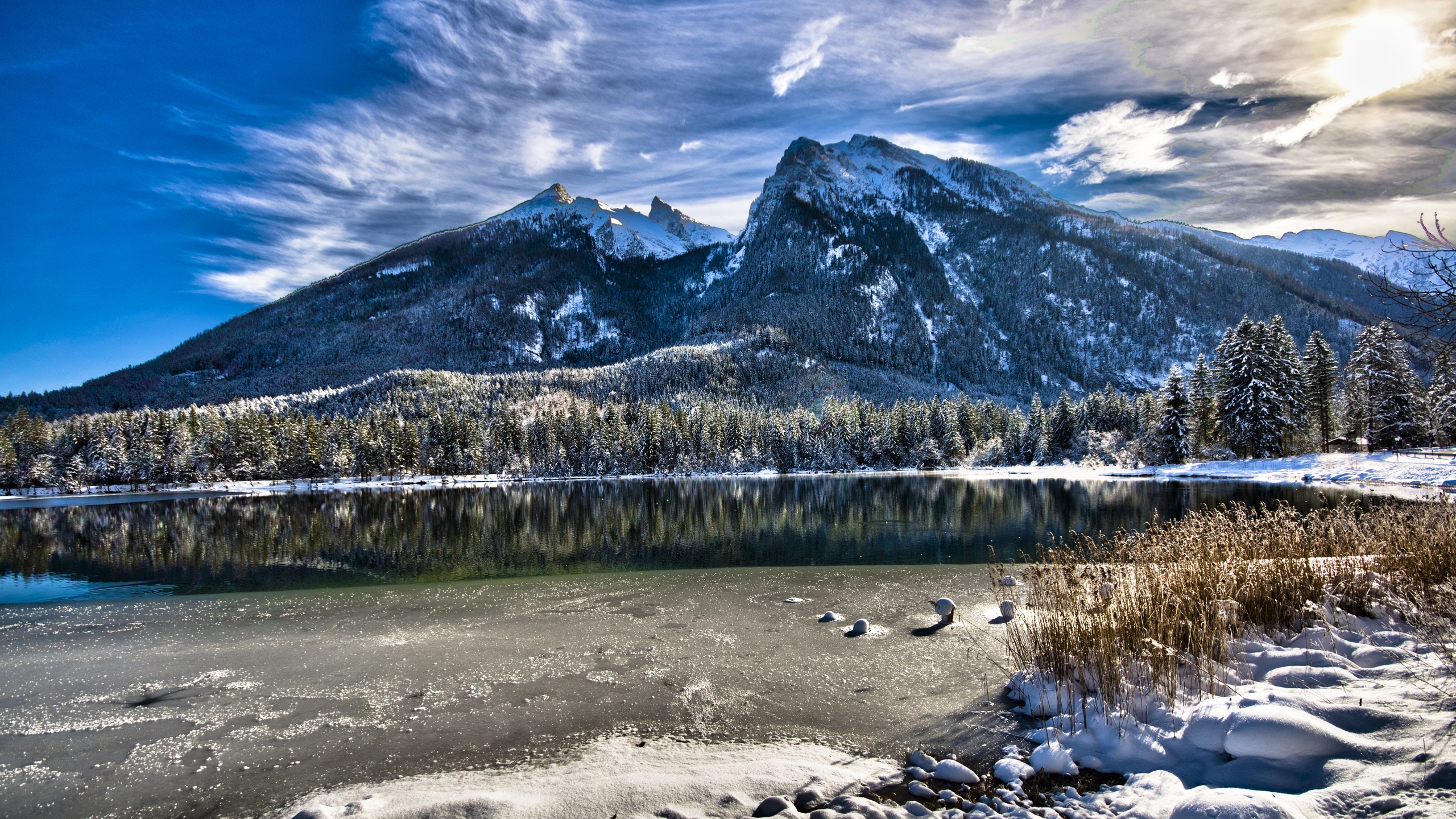 Free photo A lake in the mountains covered with ice near the shores.