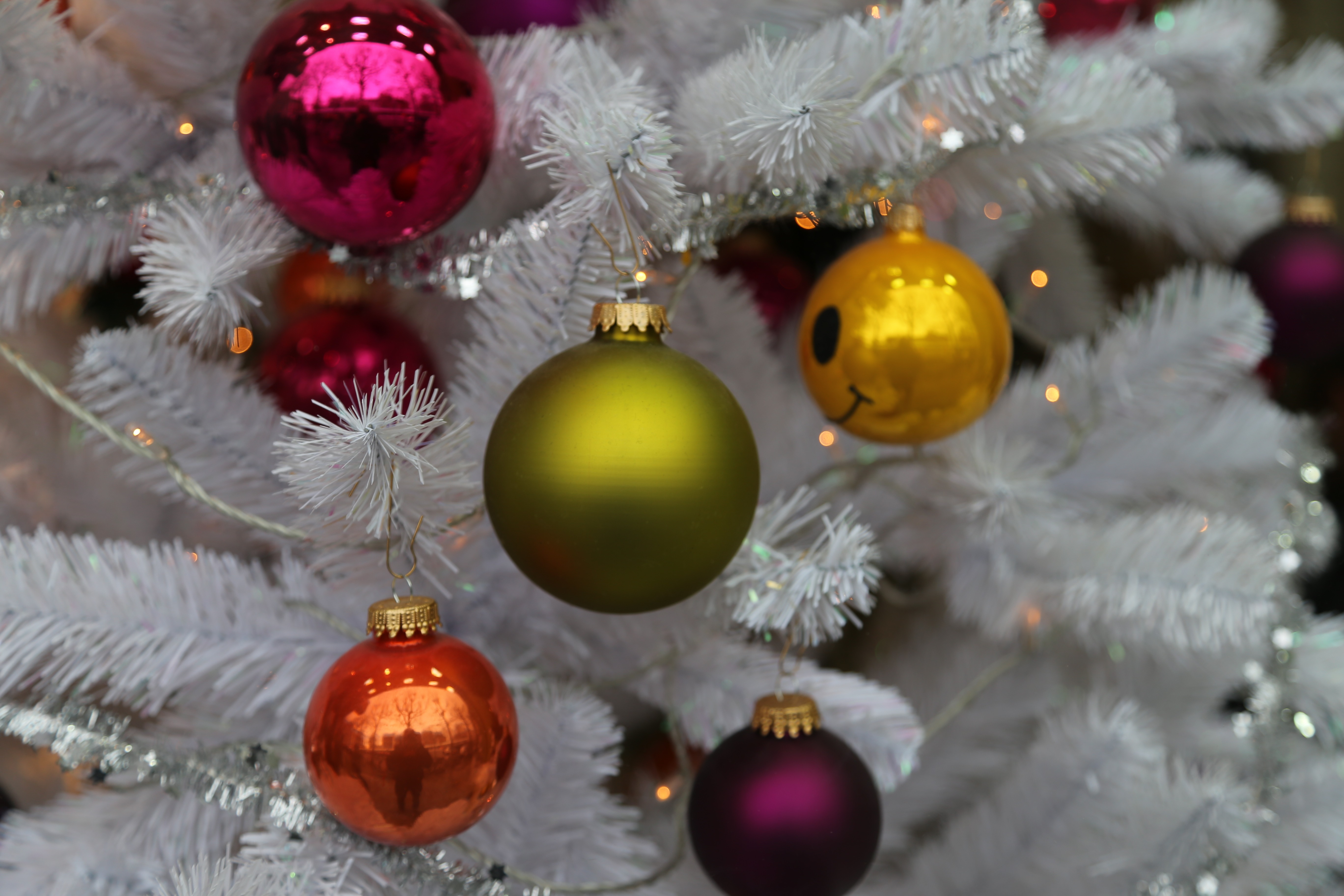 Free photo Multicolored Christmas toys on a white Christmas tree