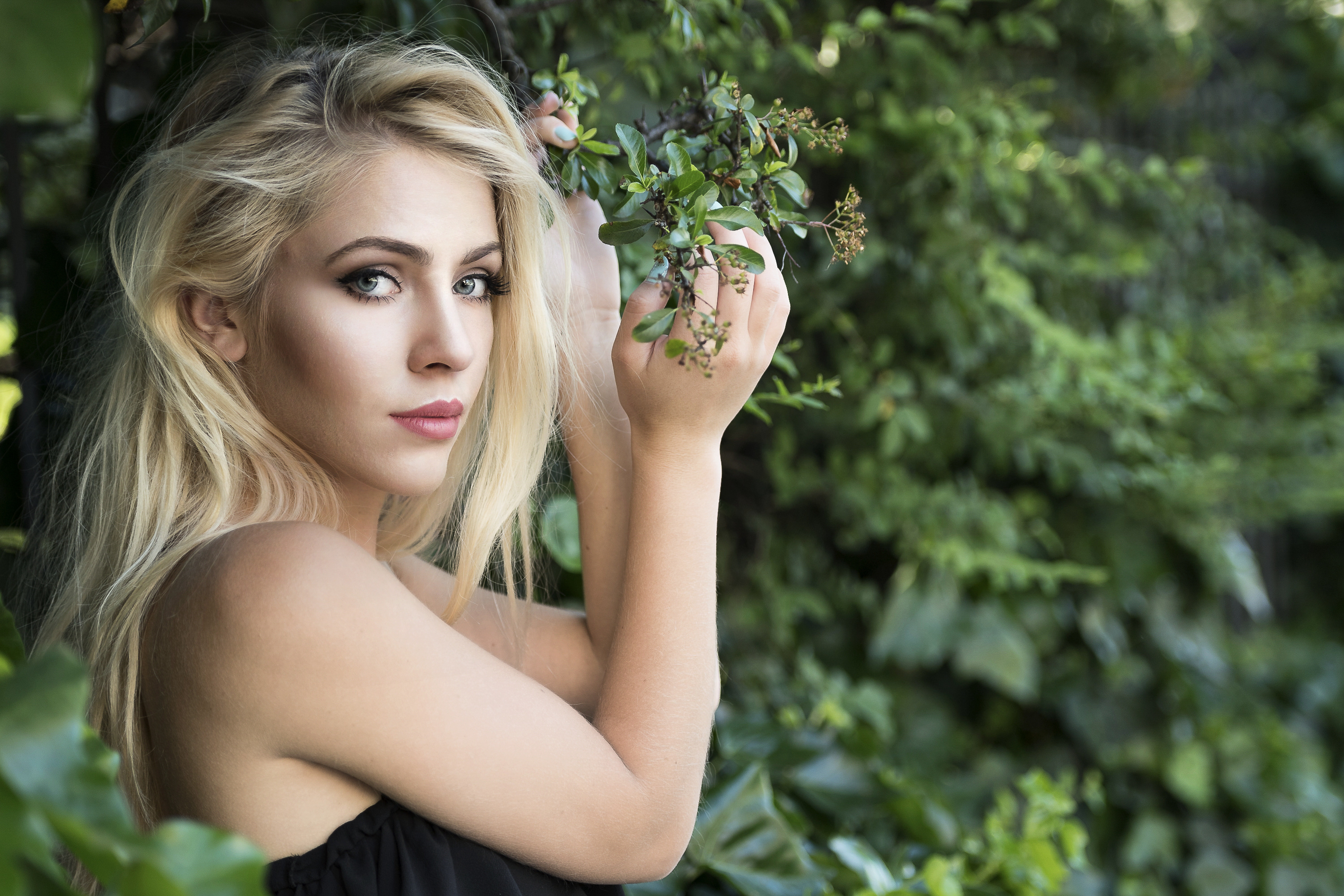 A blonde girl poses with a flower