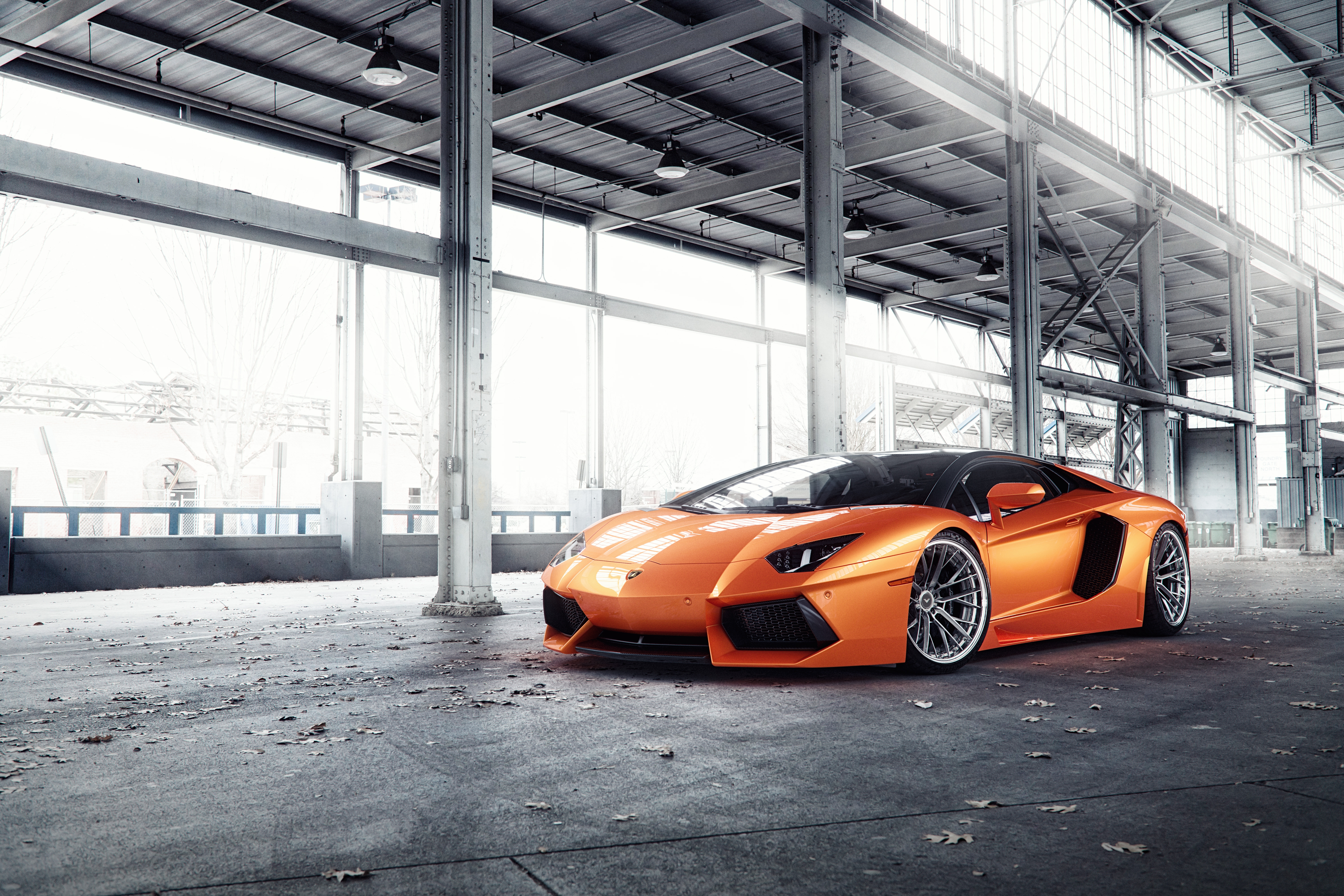 Free photo An orange lamborghini aventador on the ruins.