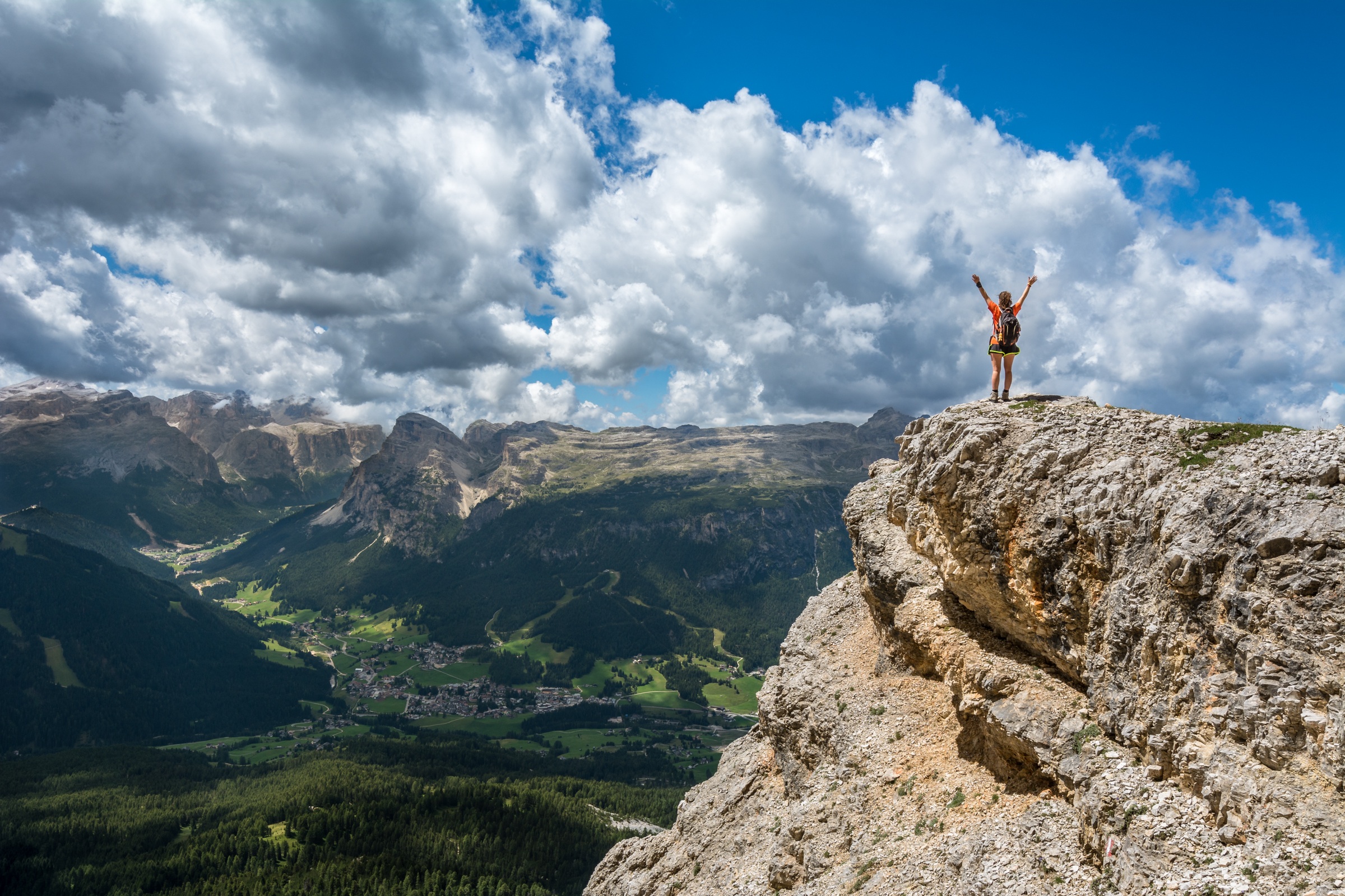 Free photo Hands up standing on the side of a mountain cliff