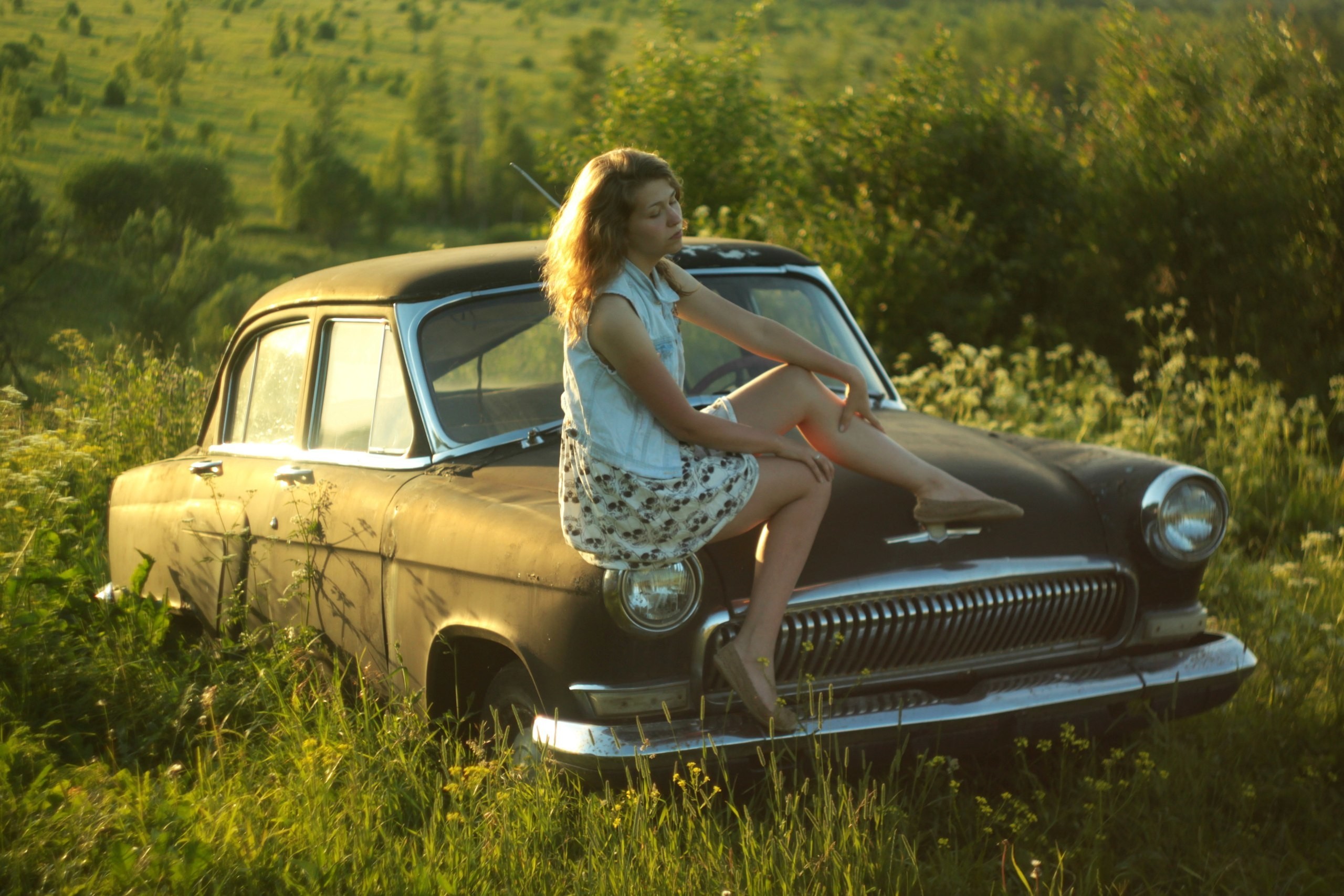 Free photo Girl sitting on the hood of a gas 21