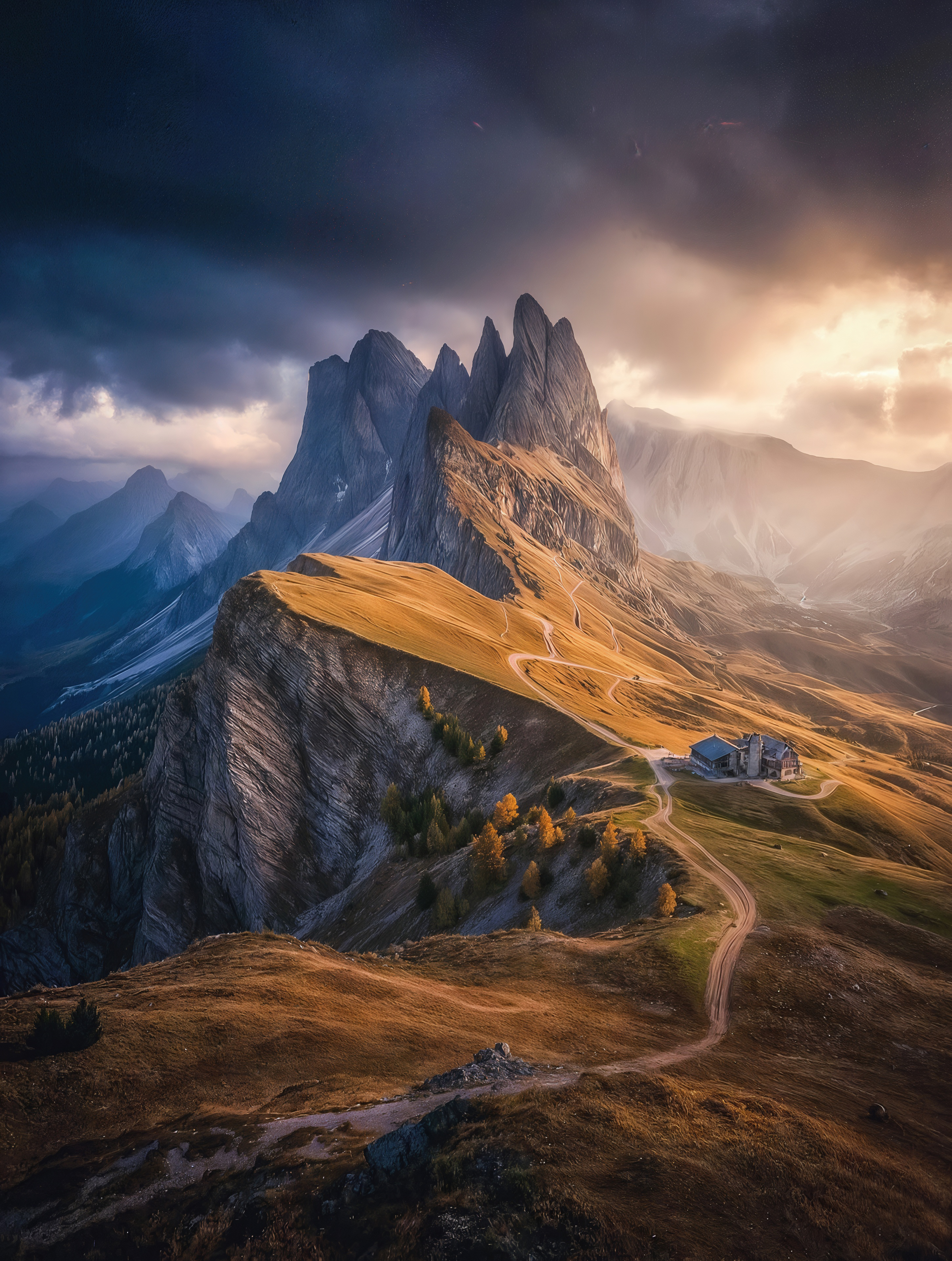 Free photo The majestic Secheda Peak in the Dolomites is illuminated by golden rays of the sun under a dramatic stormy sky.