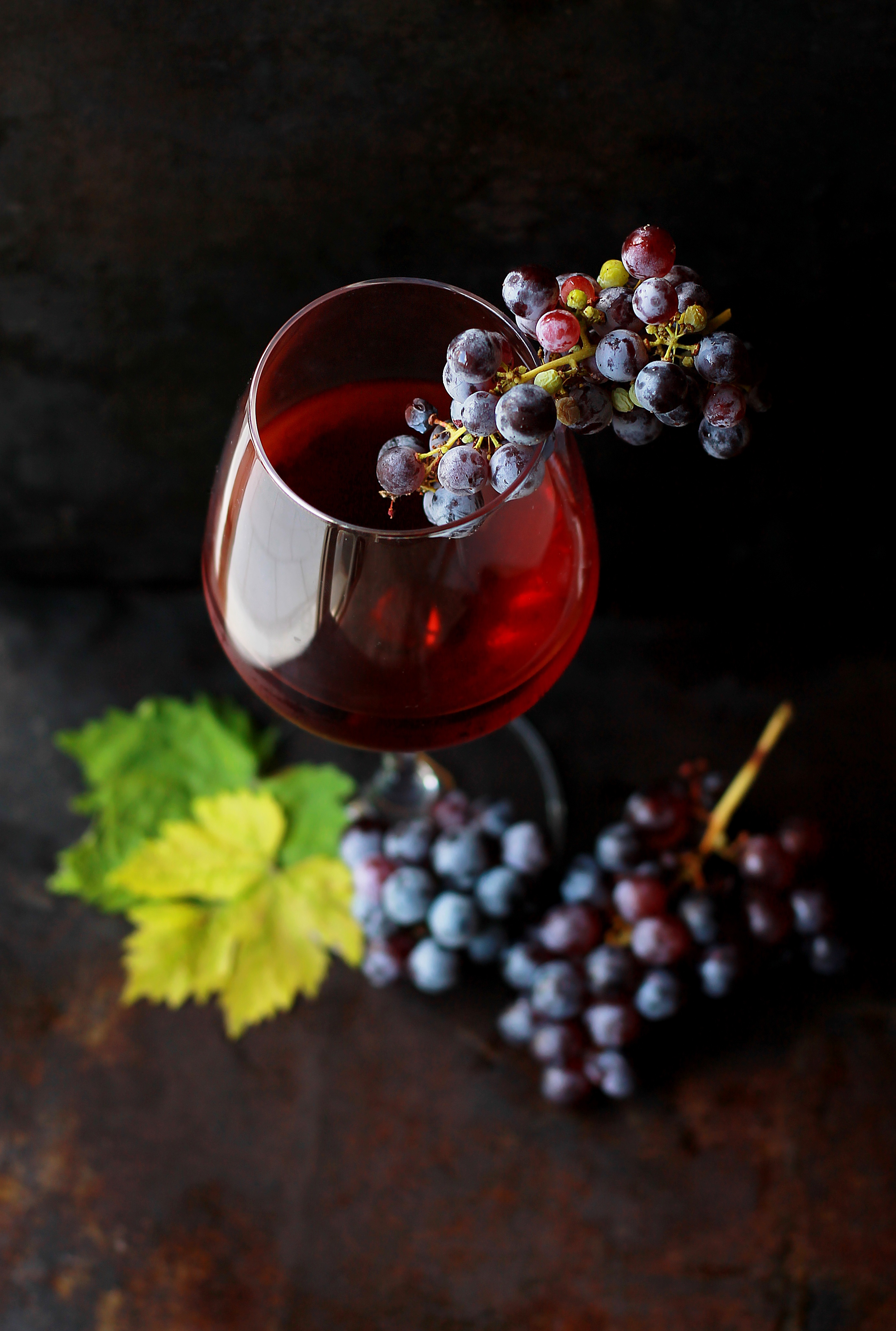 Free photo A glass of red wine and a bunch of grapes.