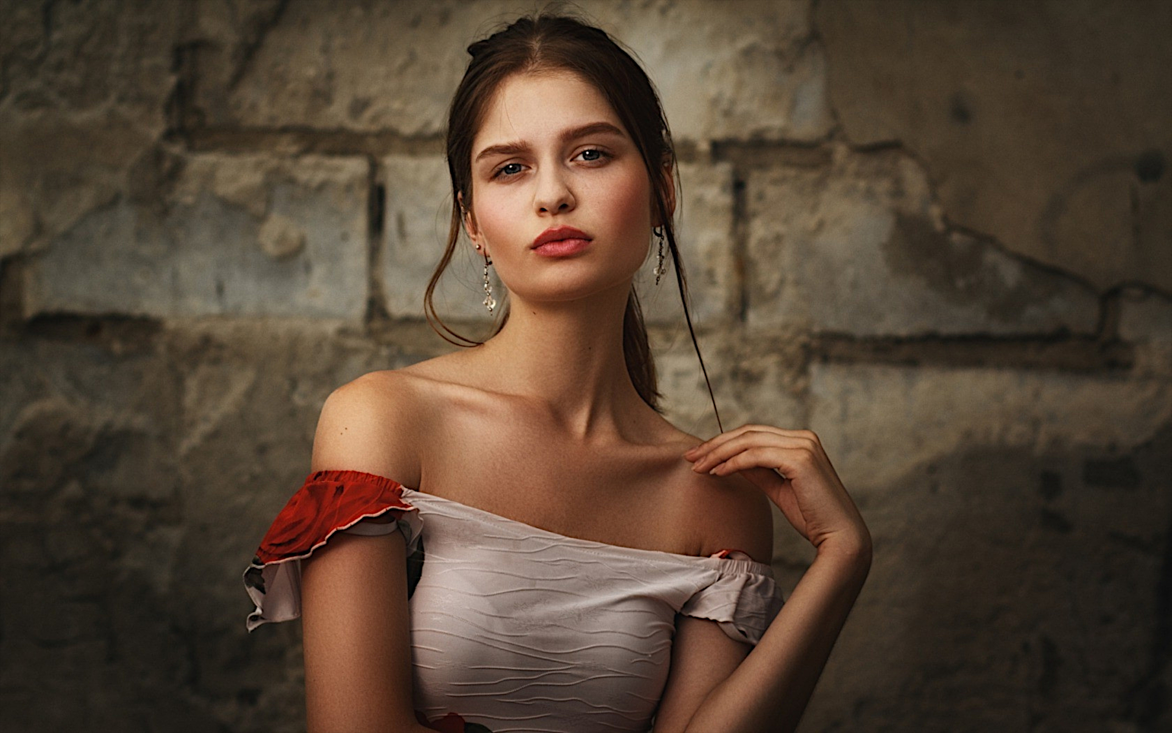 Free photo Beautiful dark-haired girl standing against the wall