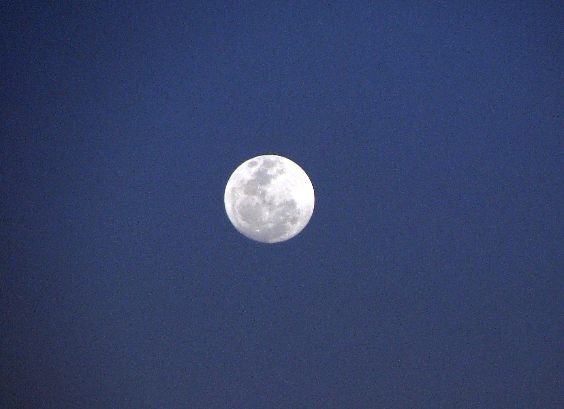 Free photo A bright moon in a dark blue sky.