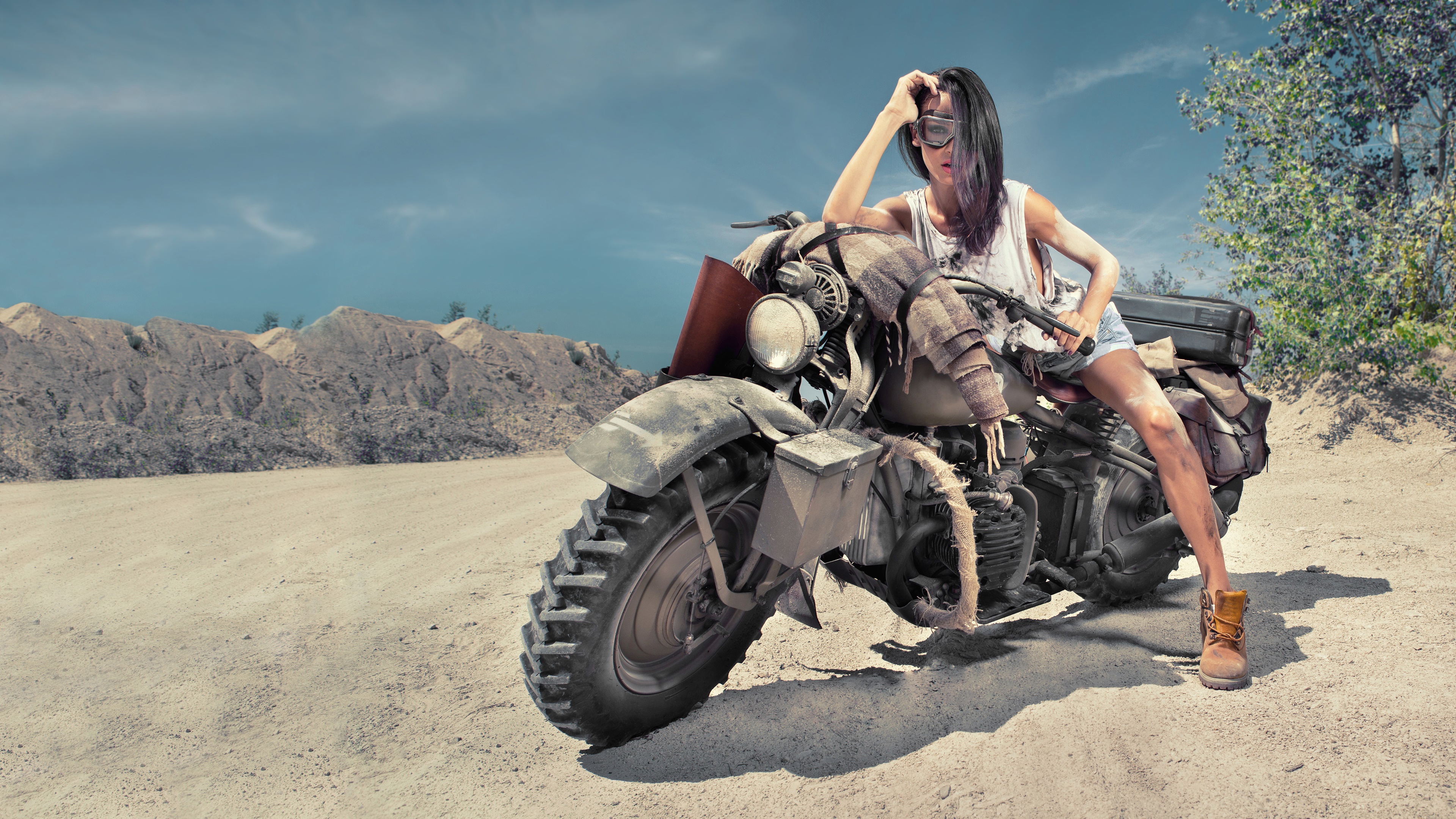 女孩在沙漠中摆出复古摩托车的姿势