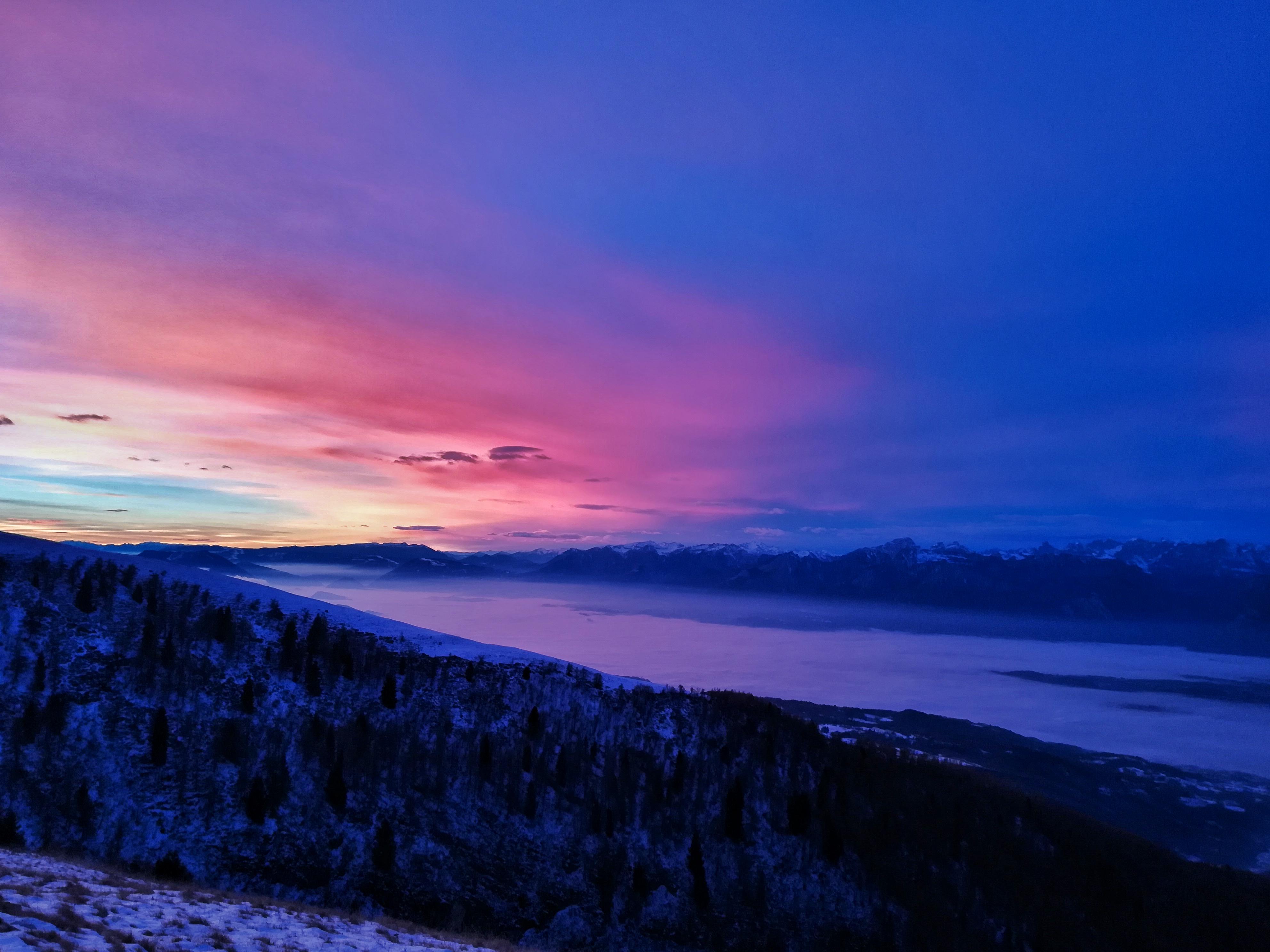 Free photo A winter sunset in a wooded area with hilly terrain