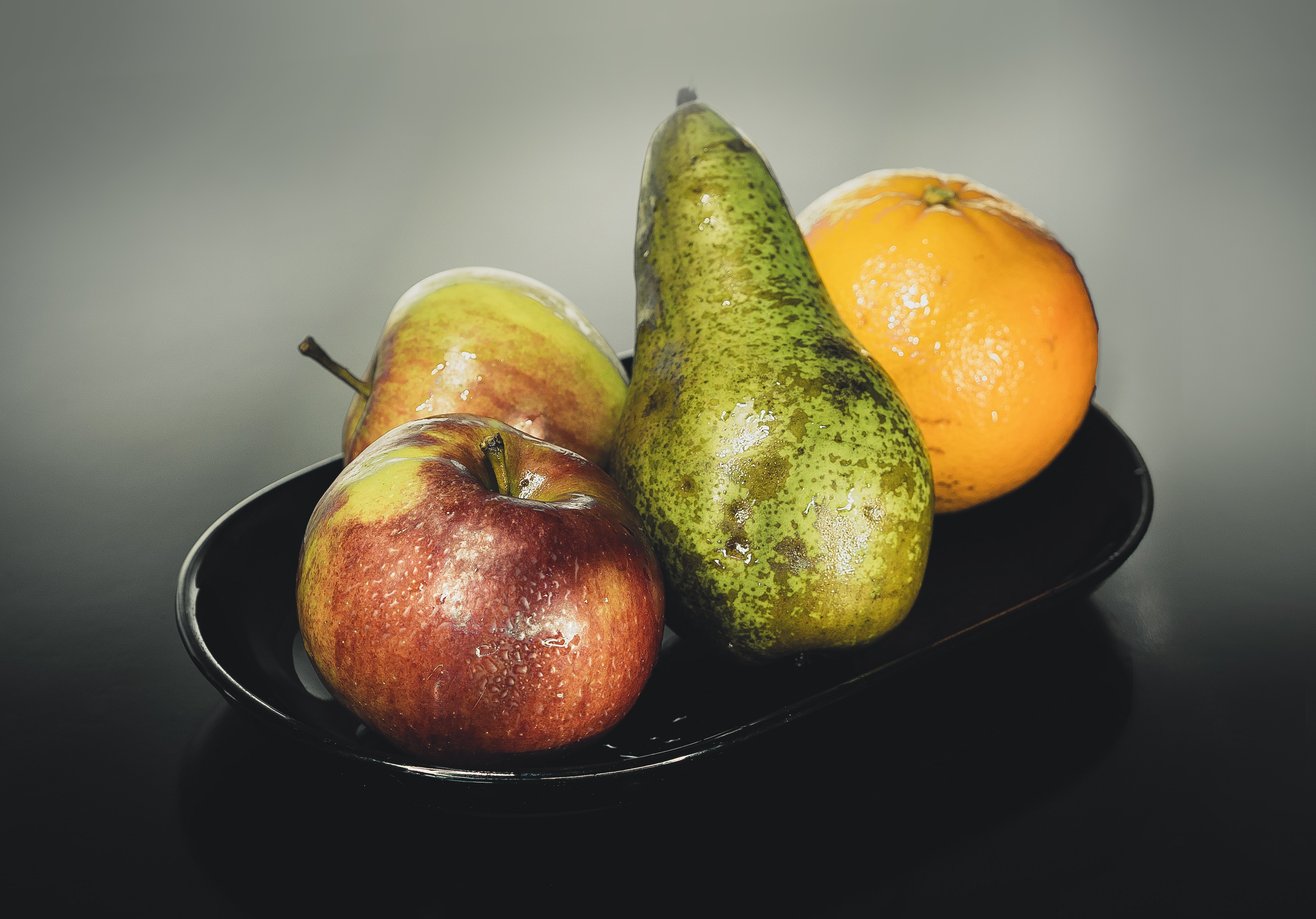 Free photo Fresh washed fruit in a black plate