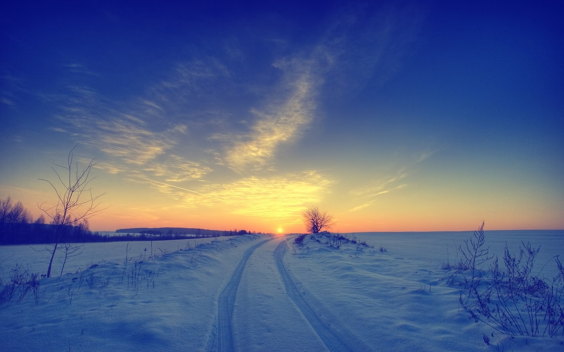 A winter field in snowdrifts at dusk