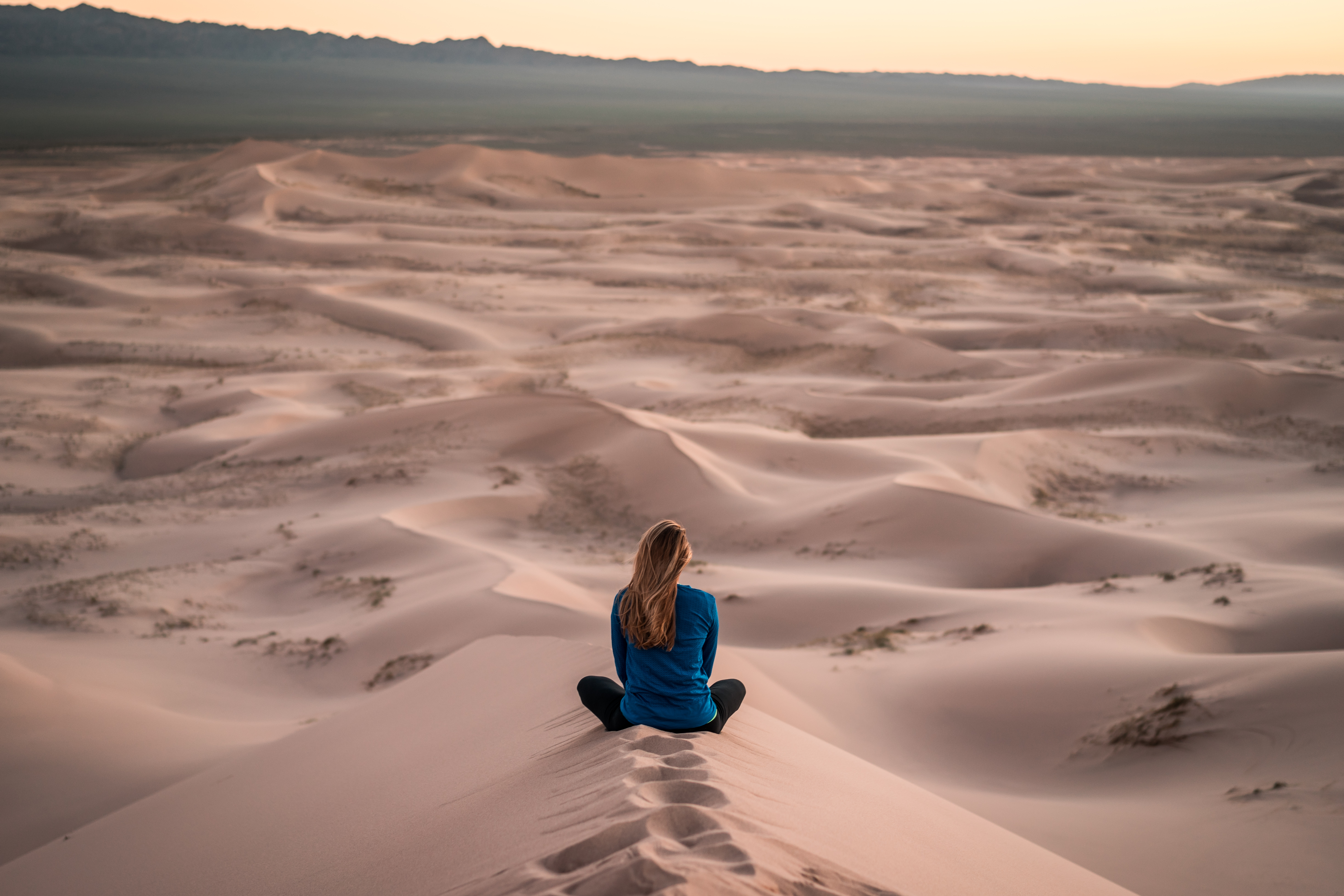 Free photo A girl sits on a sandy ridge