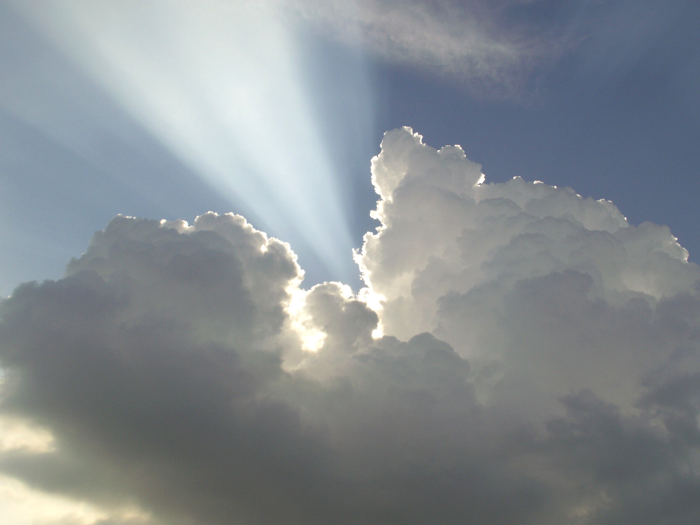 Free photo A bright ray of sunlight breaks through a thick cloud