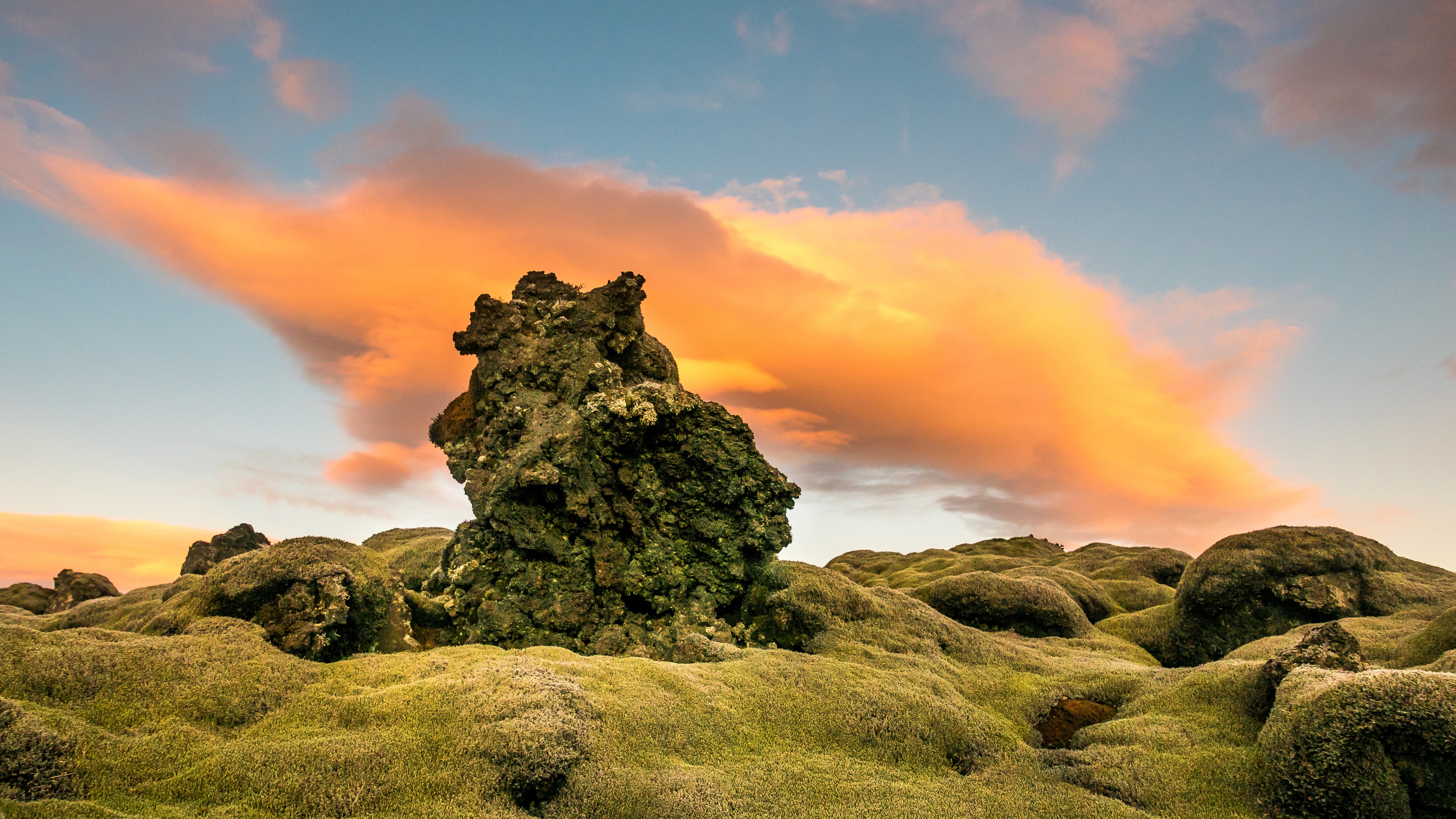 Free photo A large sharp stone lies on the green moss