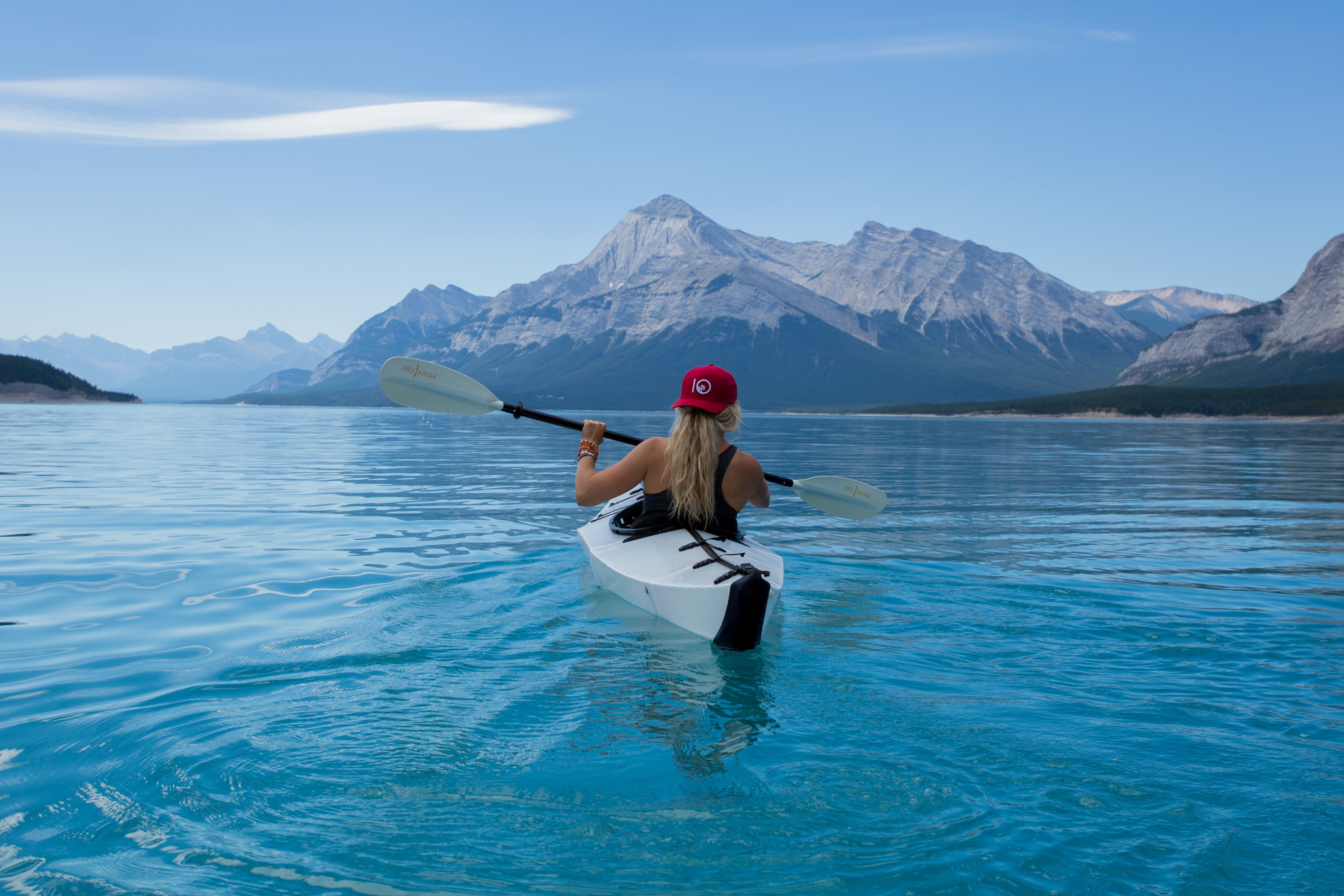 Free photo A girl paddling a kayak on the blue water