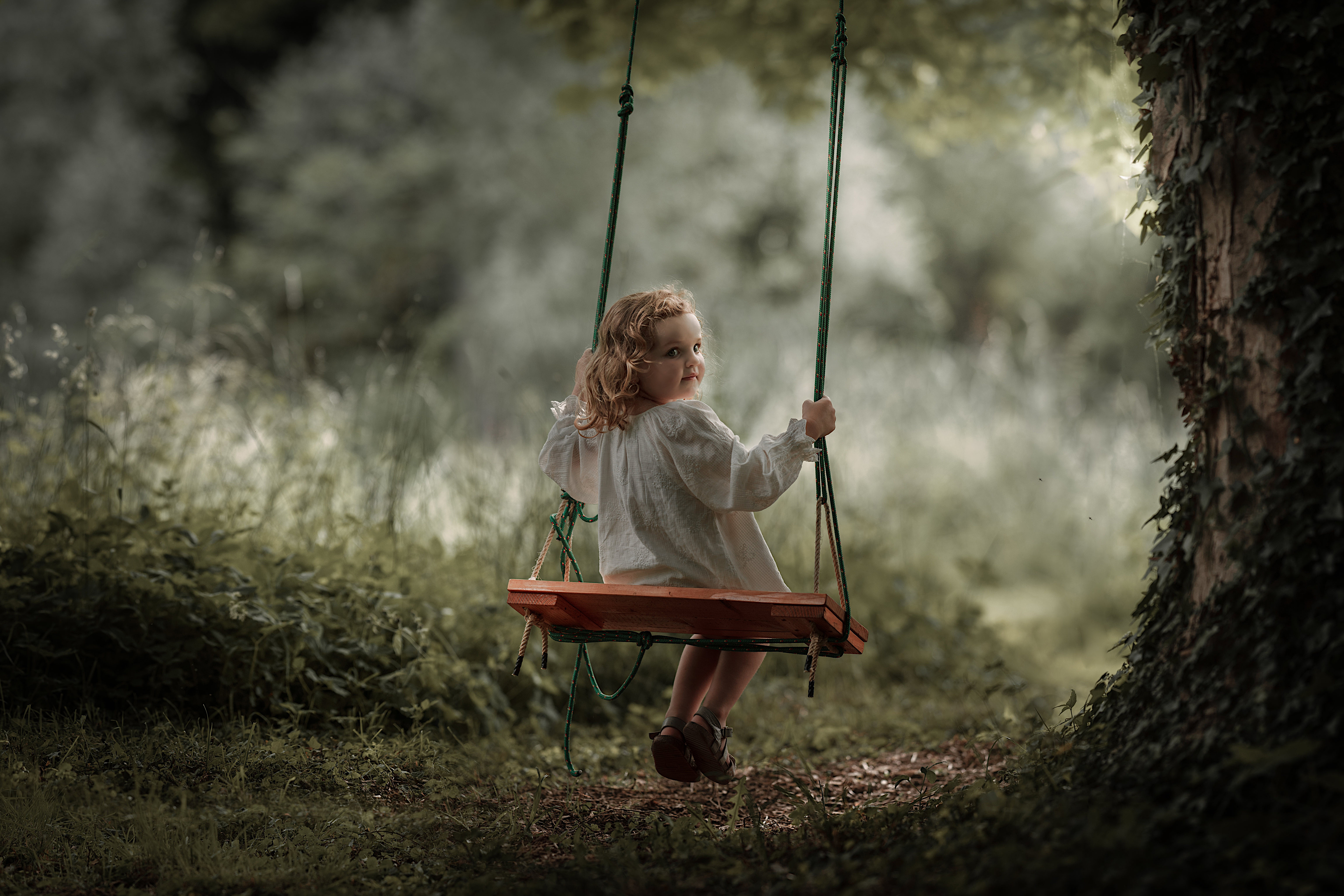 Free photo Baby angel swinging on the swing.