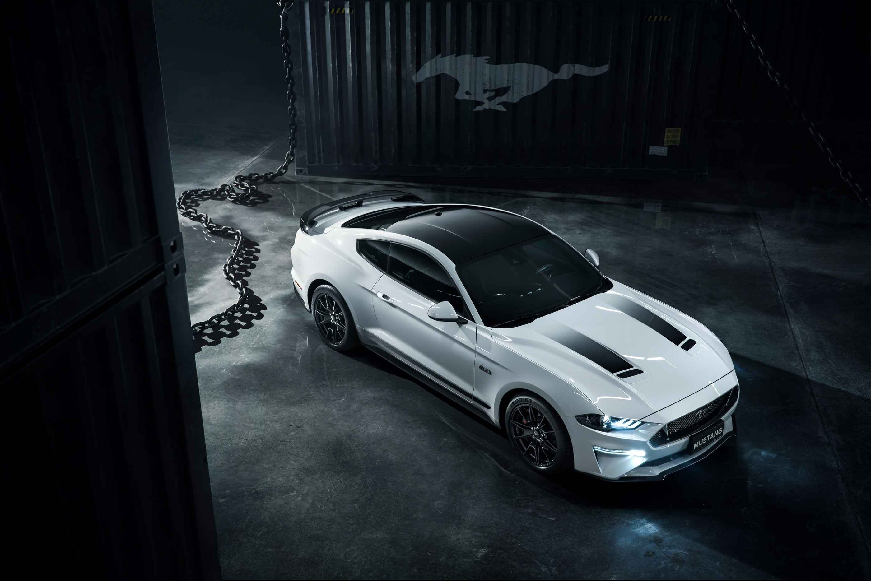 A white Ford Mustang in the dark.