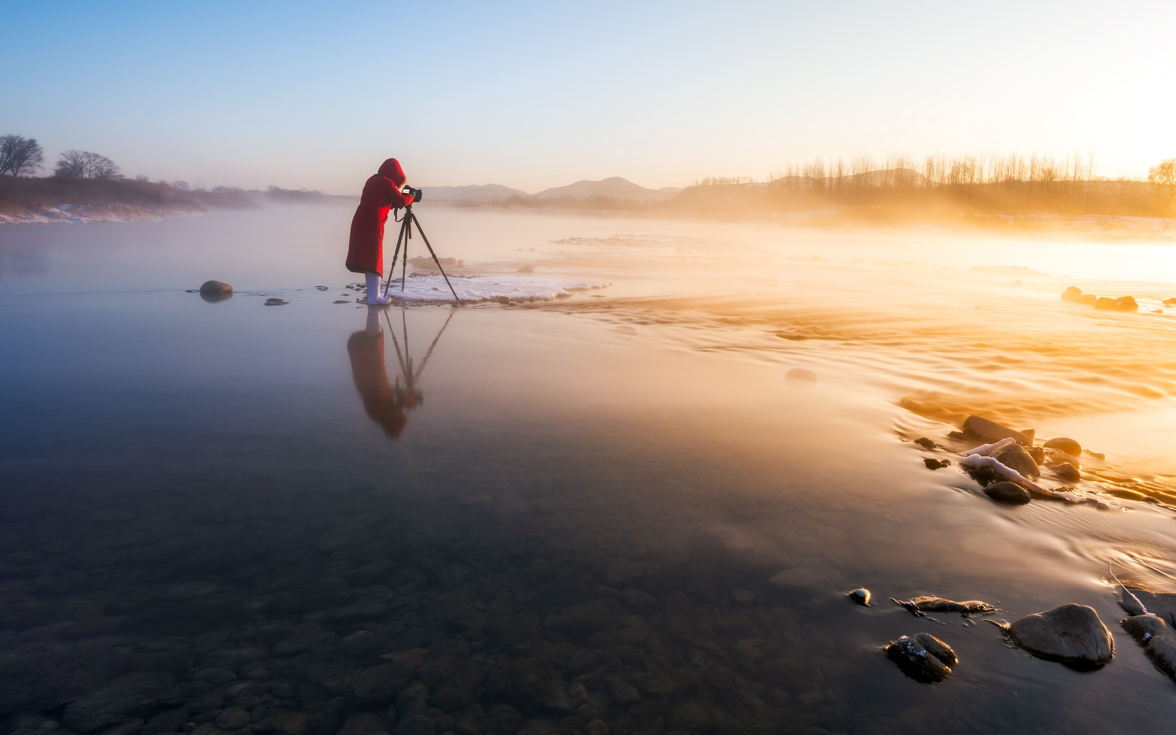 A photographer takes stunning sunrise shots on a shallow river