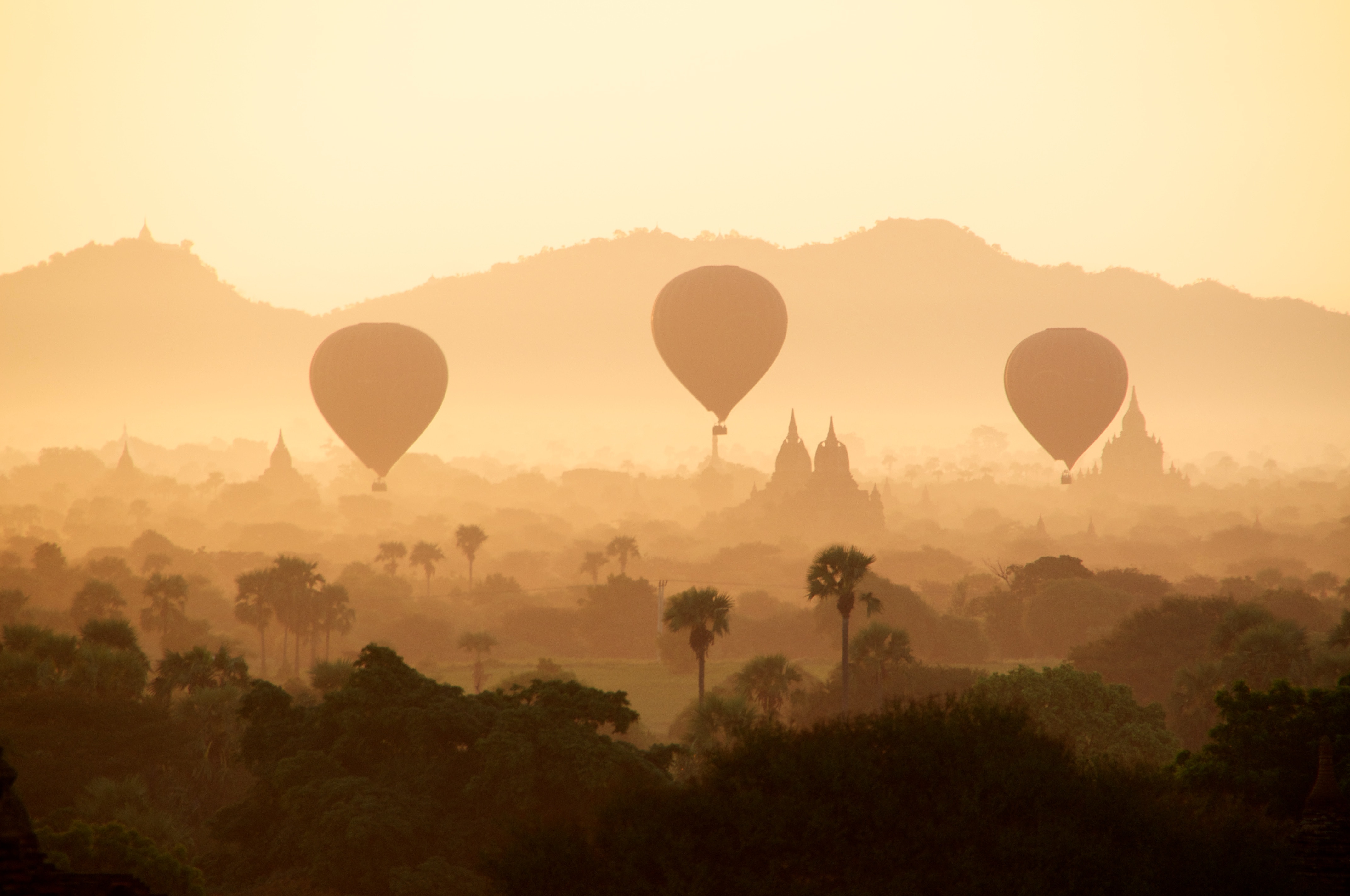 Free photo A silhouette of balloons over the city in the dust